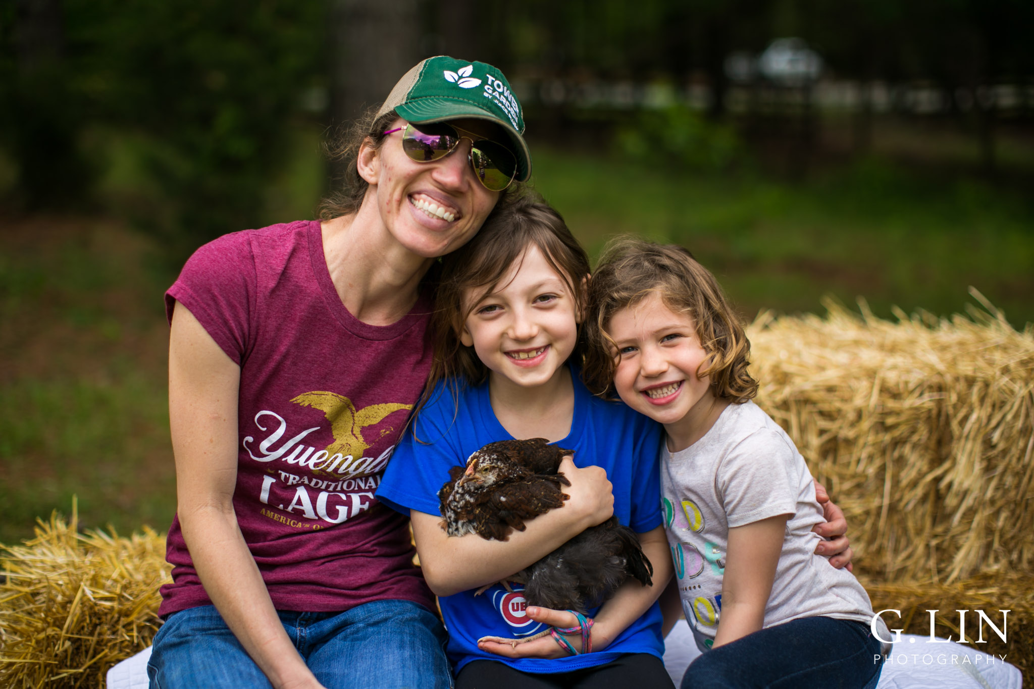 G. Lin Photography | Raleigh Event Photographer | Mom and two girls sitting on hay stack and smiling