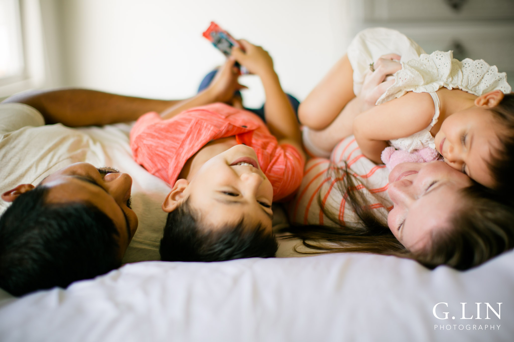 G. Lin Photography | Durham Family Photographer | Family lying down on white bed upside down
