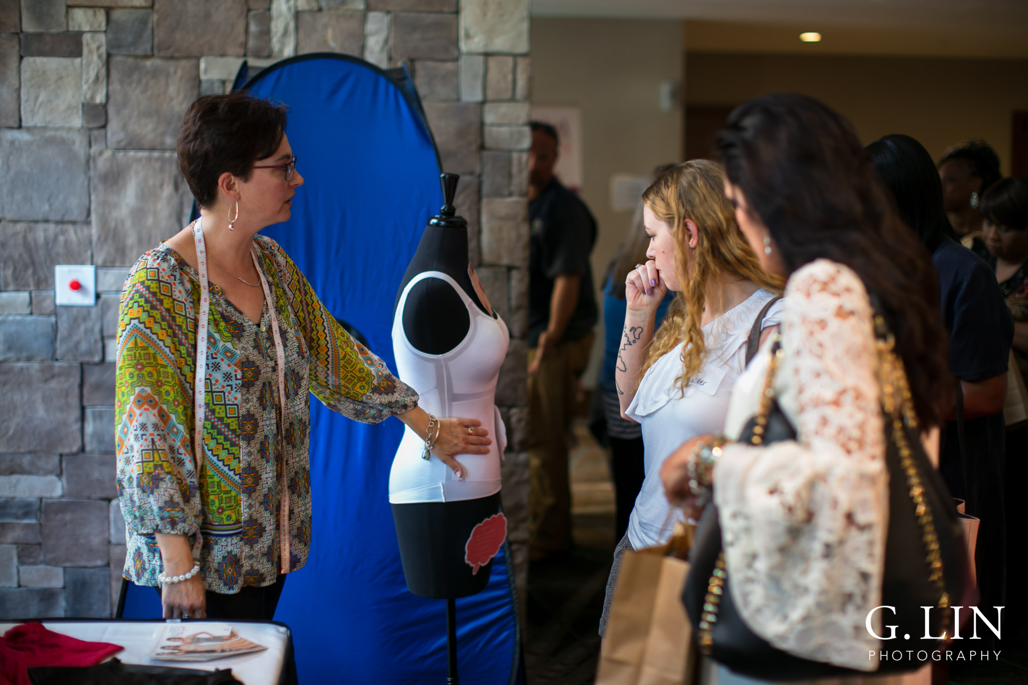 Raleigh Event Photographer | G. Lin Photography | Woman presenting clothing to guests