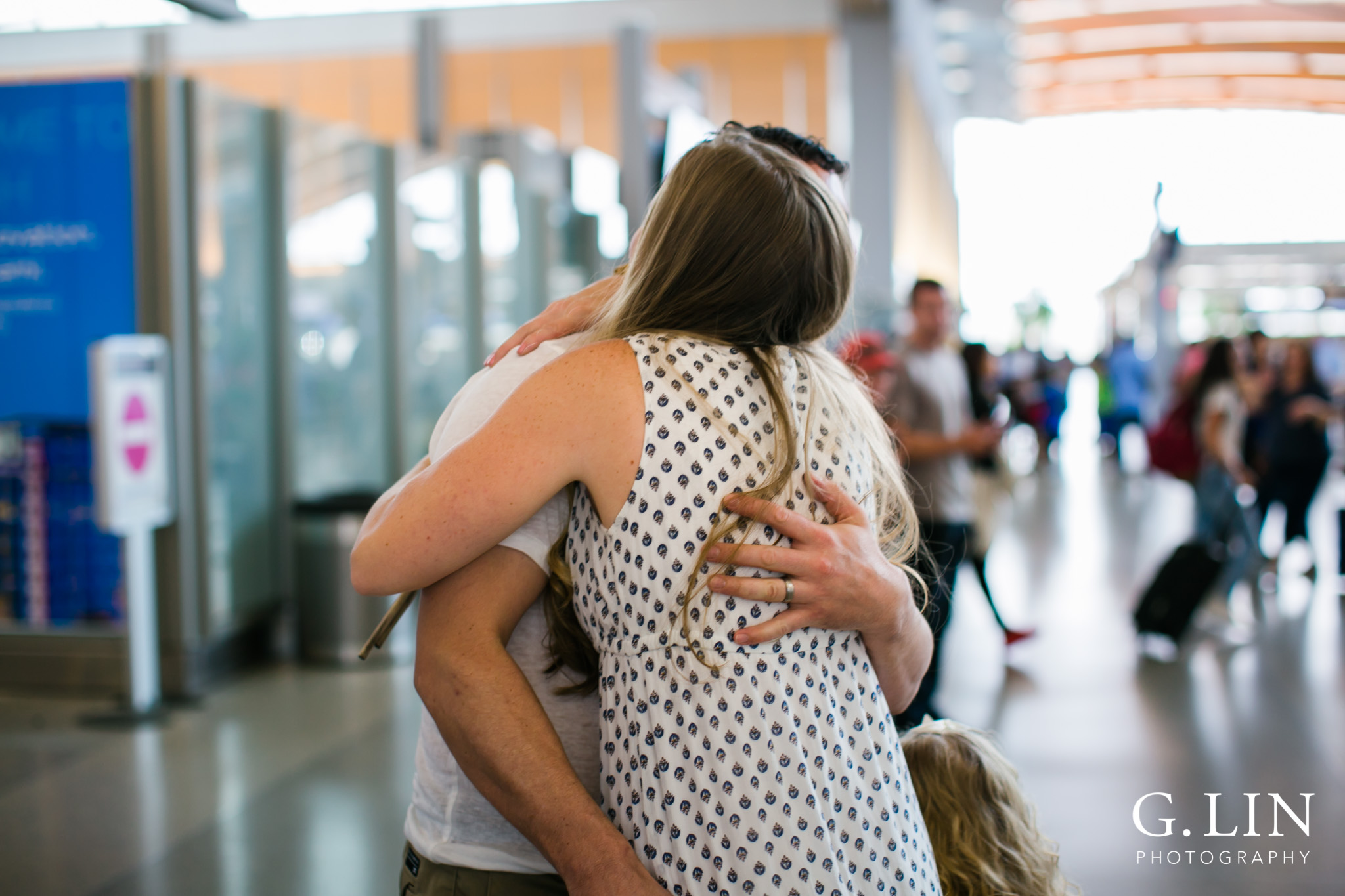 Raleigh Family Photographer | G. Lin Photography | dad hugging and greeting his wife at airport