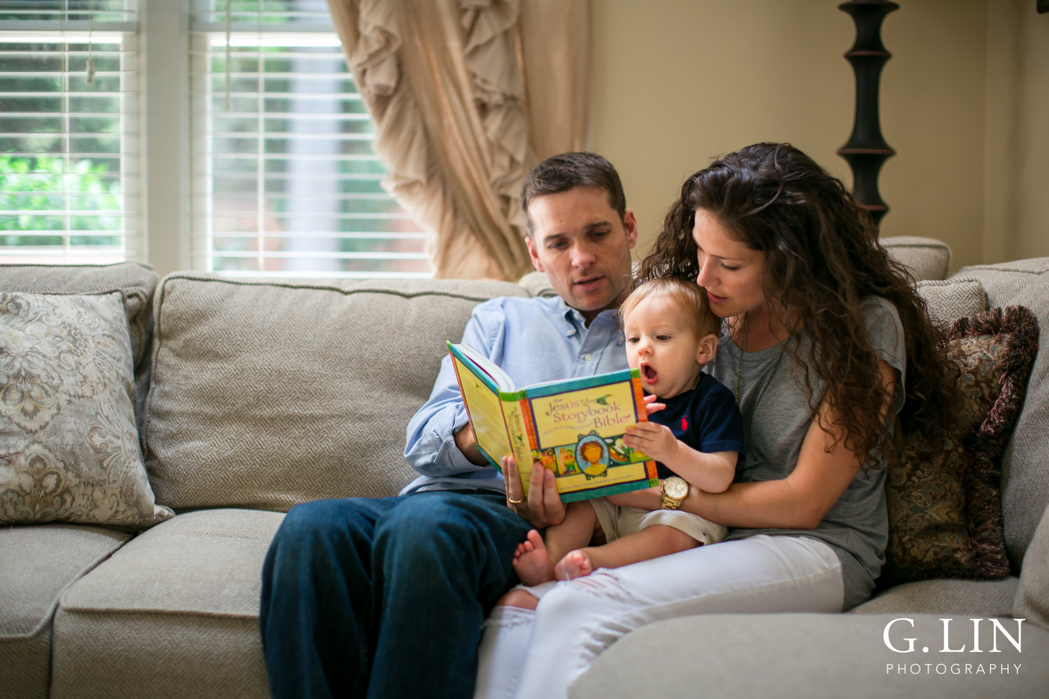 G. Lin Photography | Raleigh Lifestyle Photographer | Family of three reading Jesus storybook bible on couch