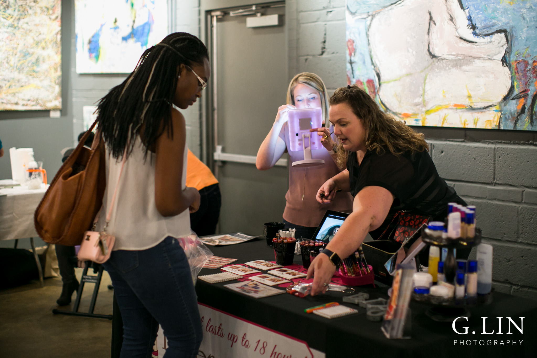 Raleigh Event Photographer | G. Lin Photography | Woman showing lip products to customer