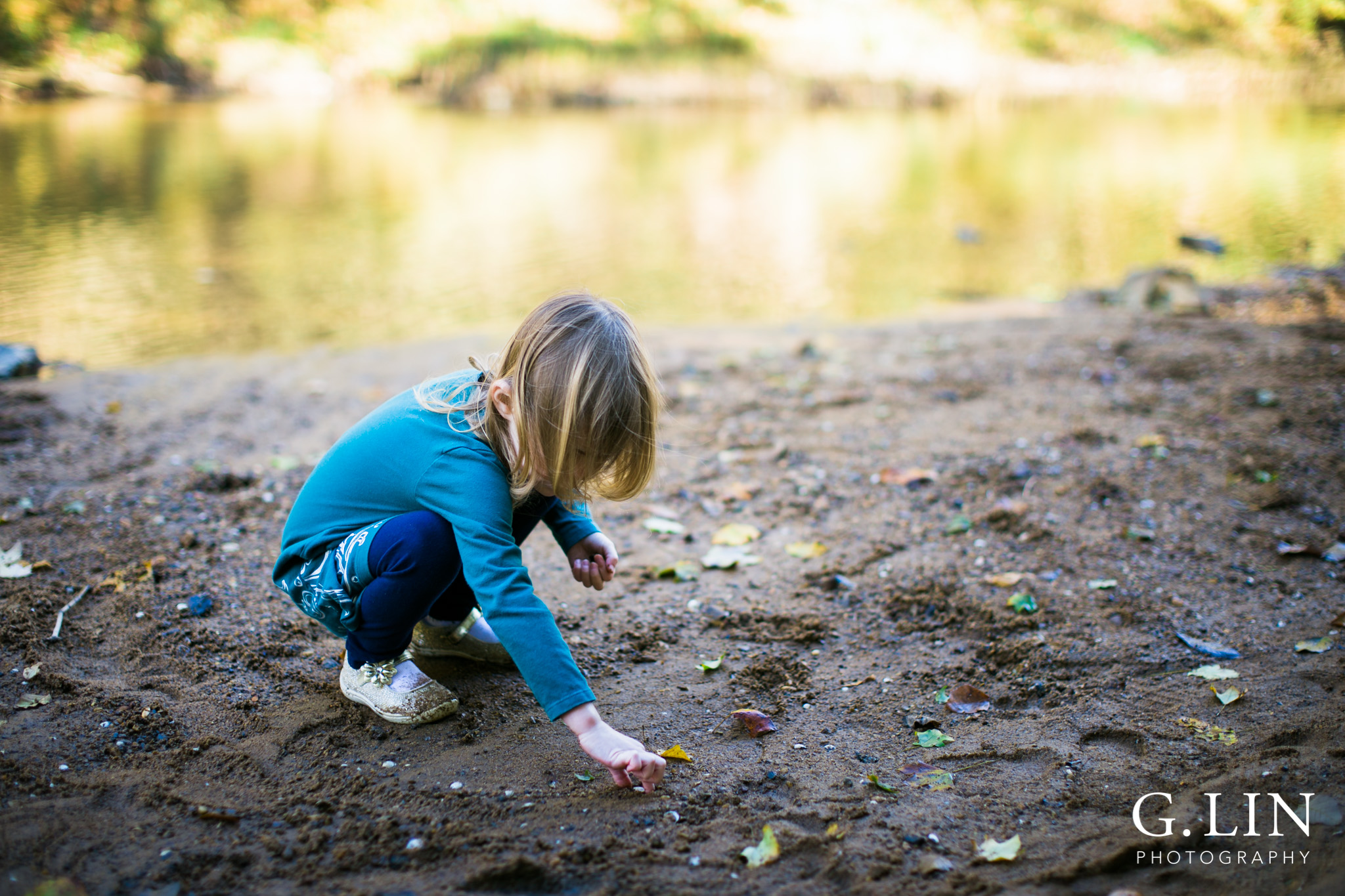 Durham Family Photographer | G. Lin Photography | Close up of child playing by the river and holding sand