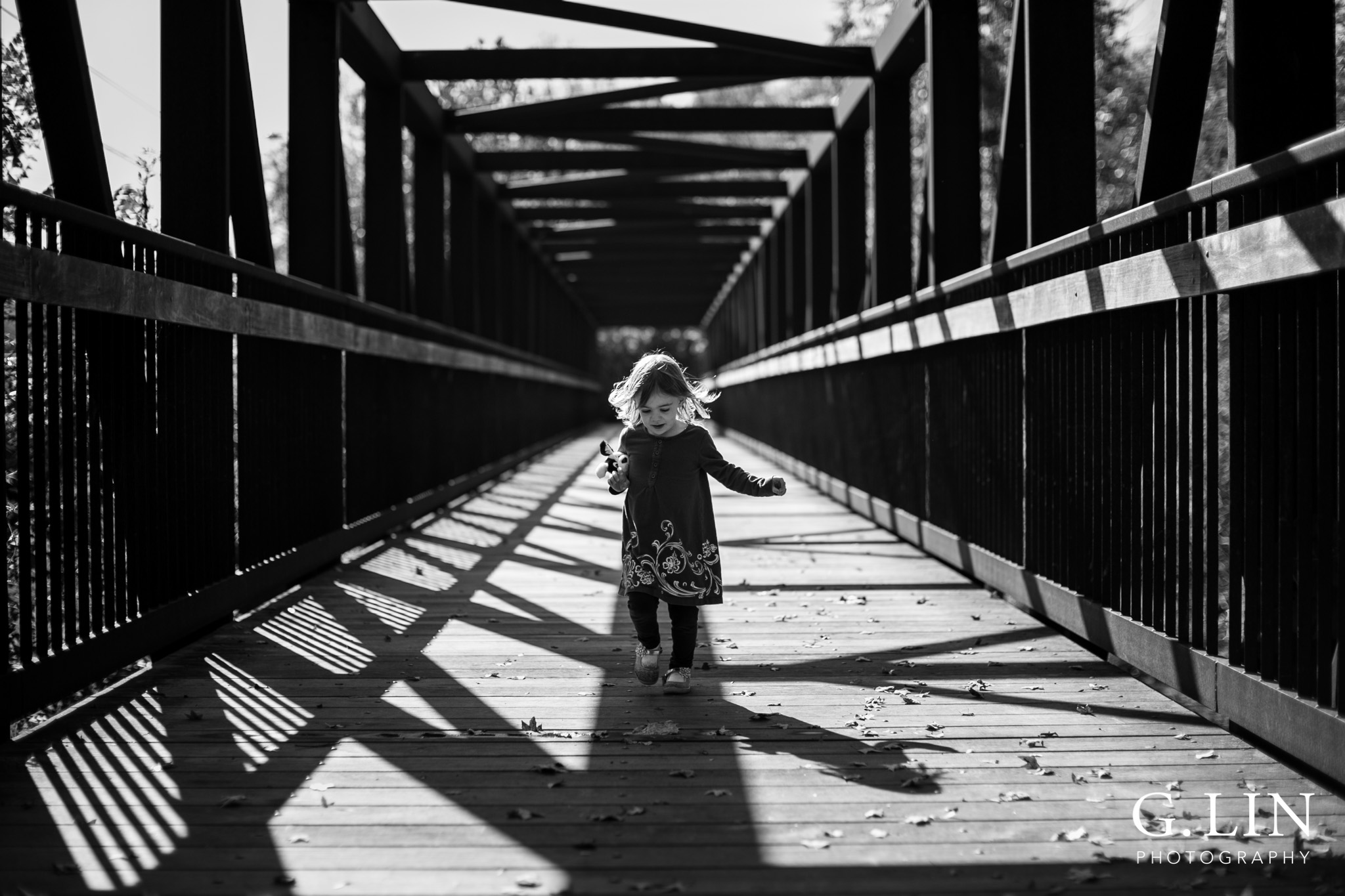Durham Family Photographer | G. Lin Photography | Little girl running across a bridge towards camera