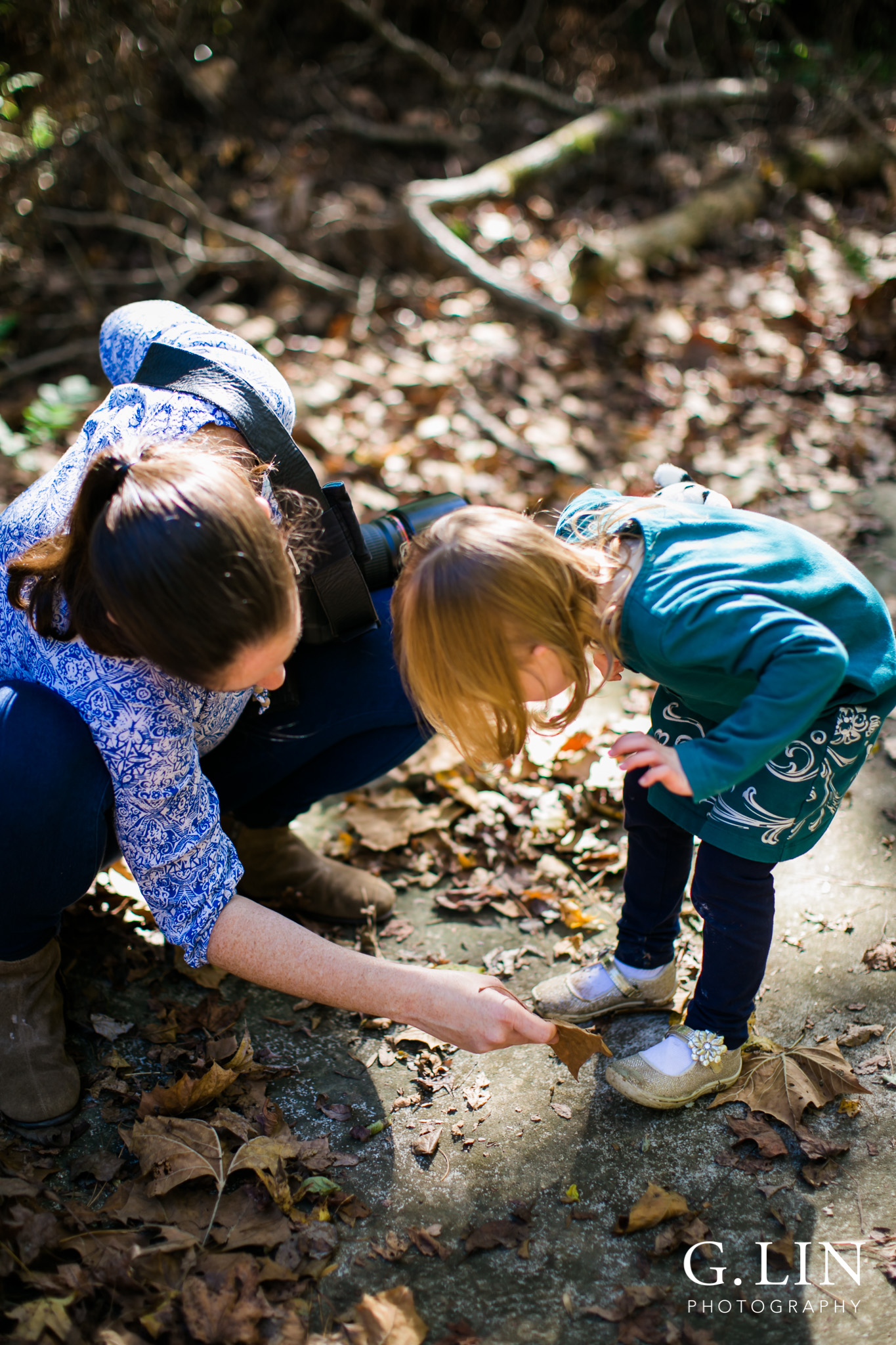 Durham Family Photographer | G. Lin Photography | Mother wiping off dirt from daughter's shoes