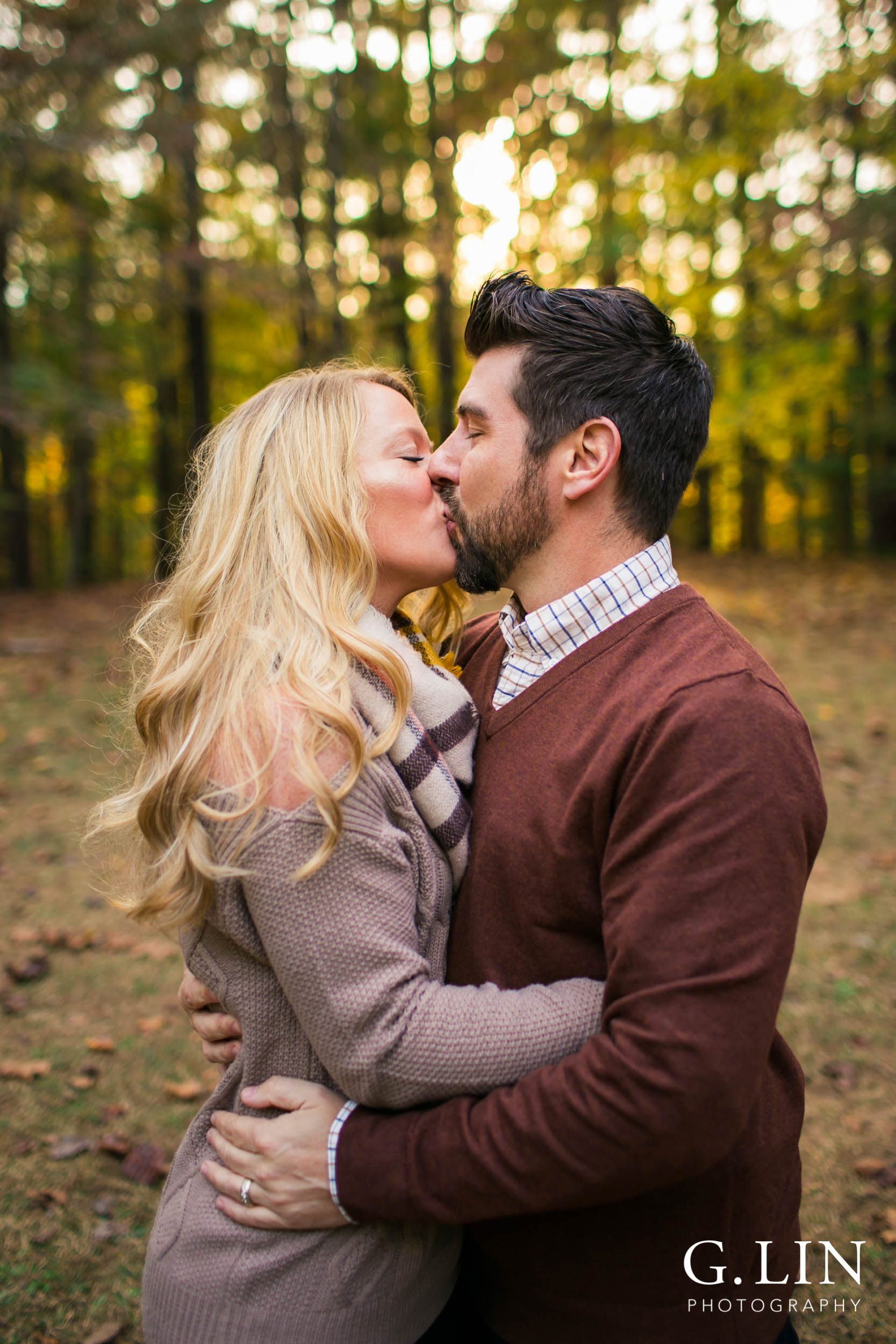 Raleigh Family Photographer | G. Lin Photography | Mom and dad kissing each other at Umstead park