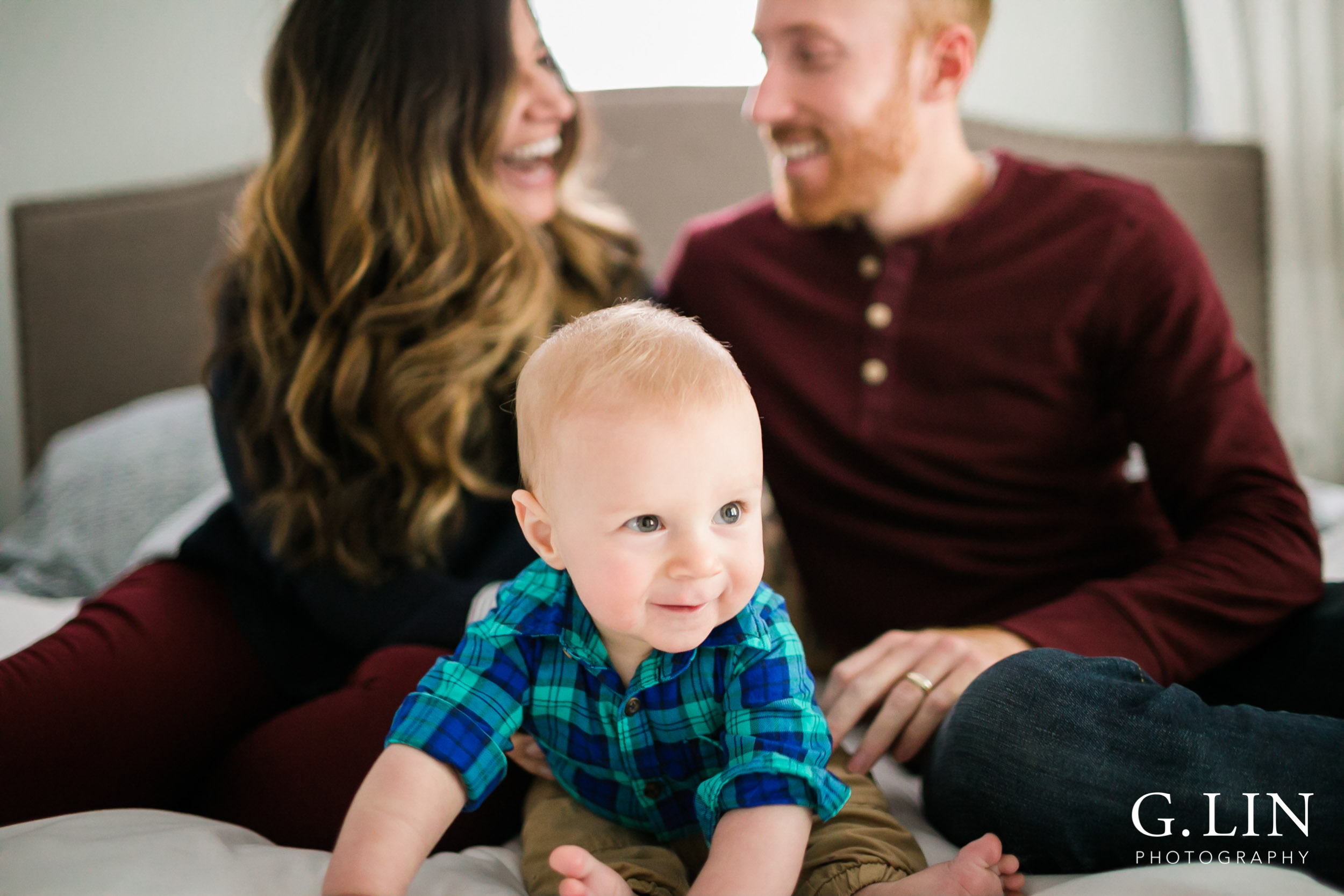 Durham Family Photographer | G. Lin Photography | Curious baby sitting on bed with parents