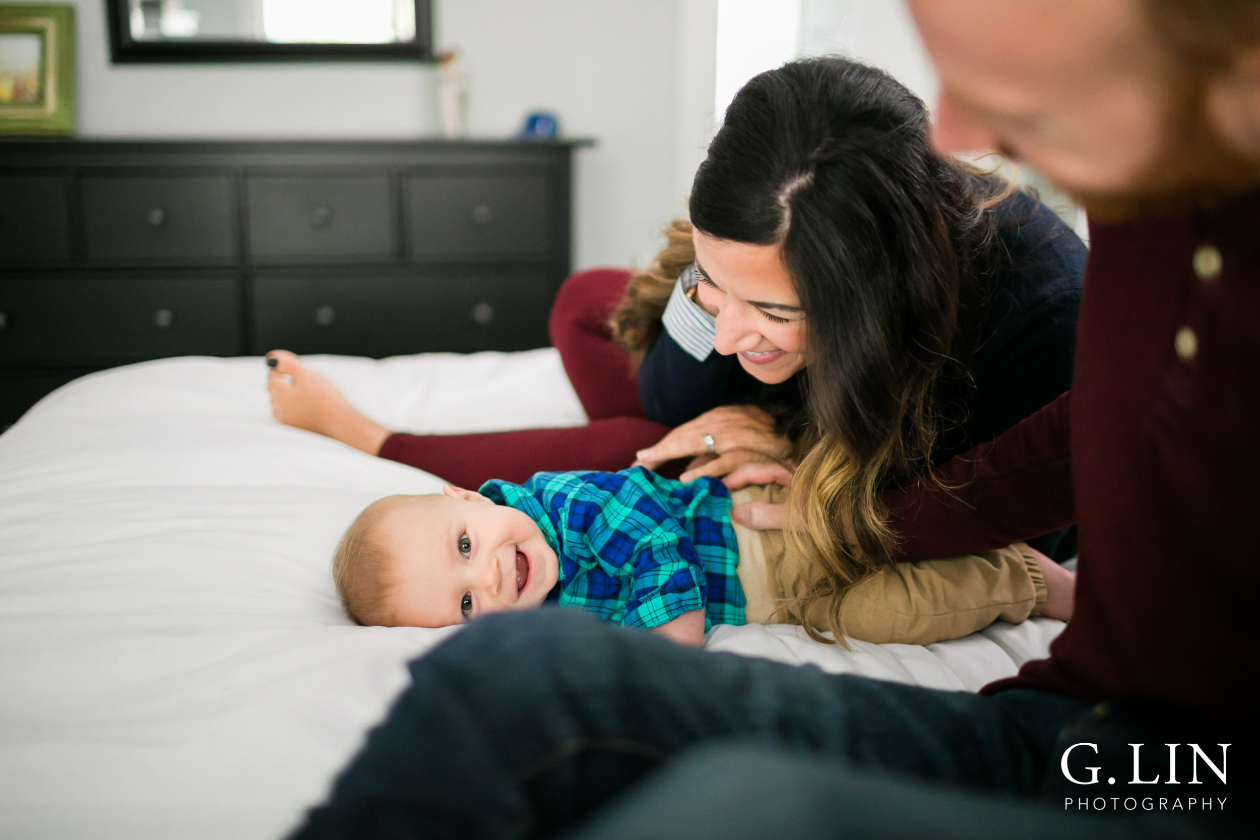 Durham Family Photographer | G. Lin Photography | Smiling baby laughing with parents on bed