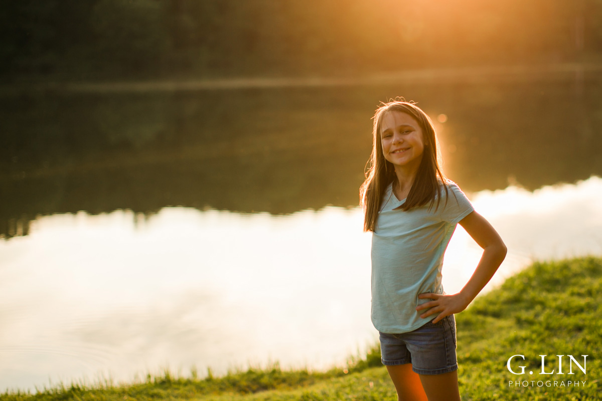 Raleigh Family Photographer | By G. Lin Photography | Girl smiling at camera by the lake during sunset