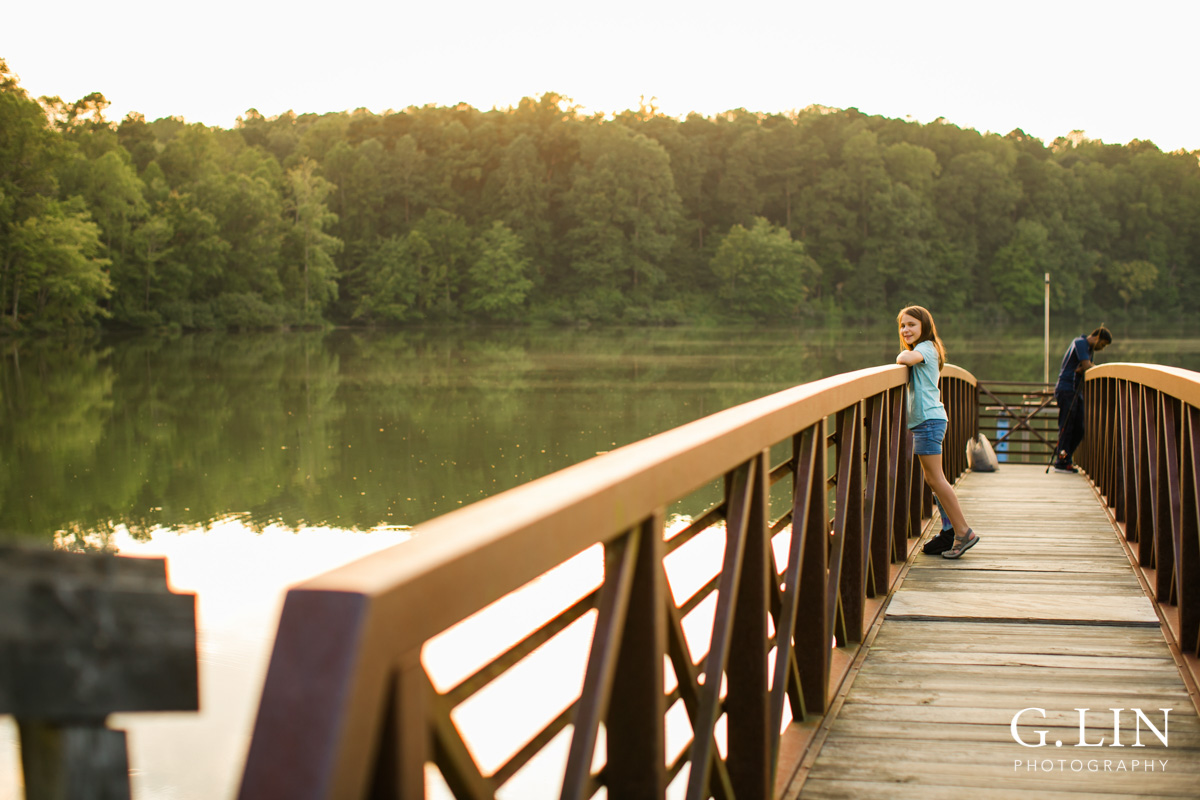 Raleigh Family Photographer | By G. Lin Photography | Girl on Umstead Park bridge looking at camera