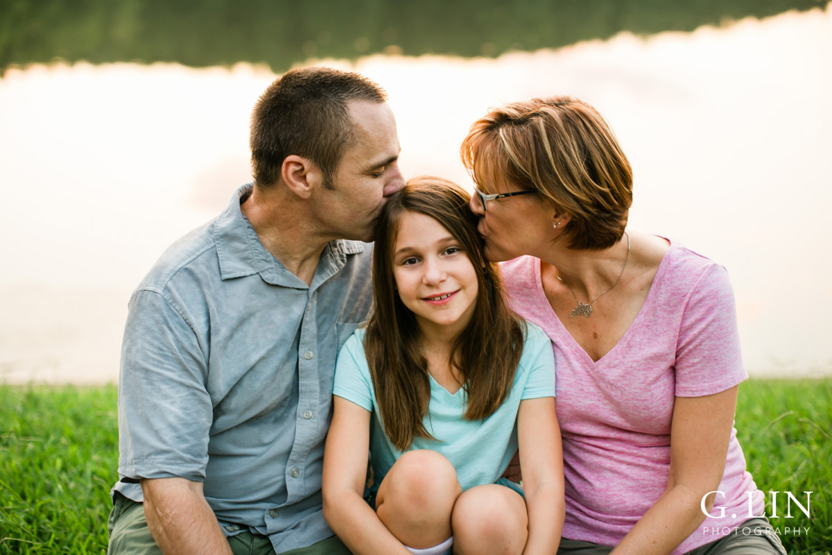 Raleigh Family Photographer | By G. Lin Photography | Mother and father kissing daughter on the head