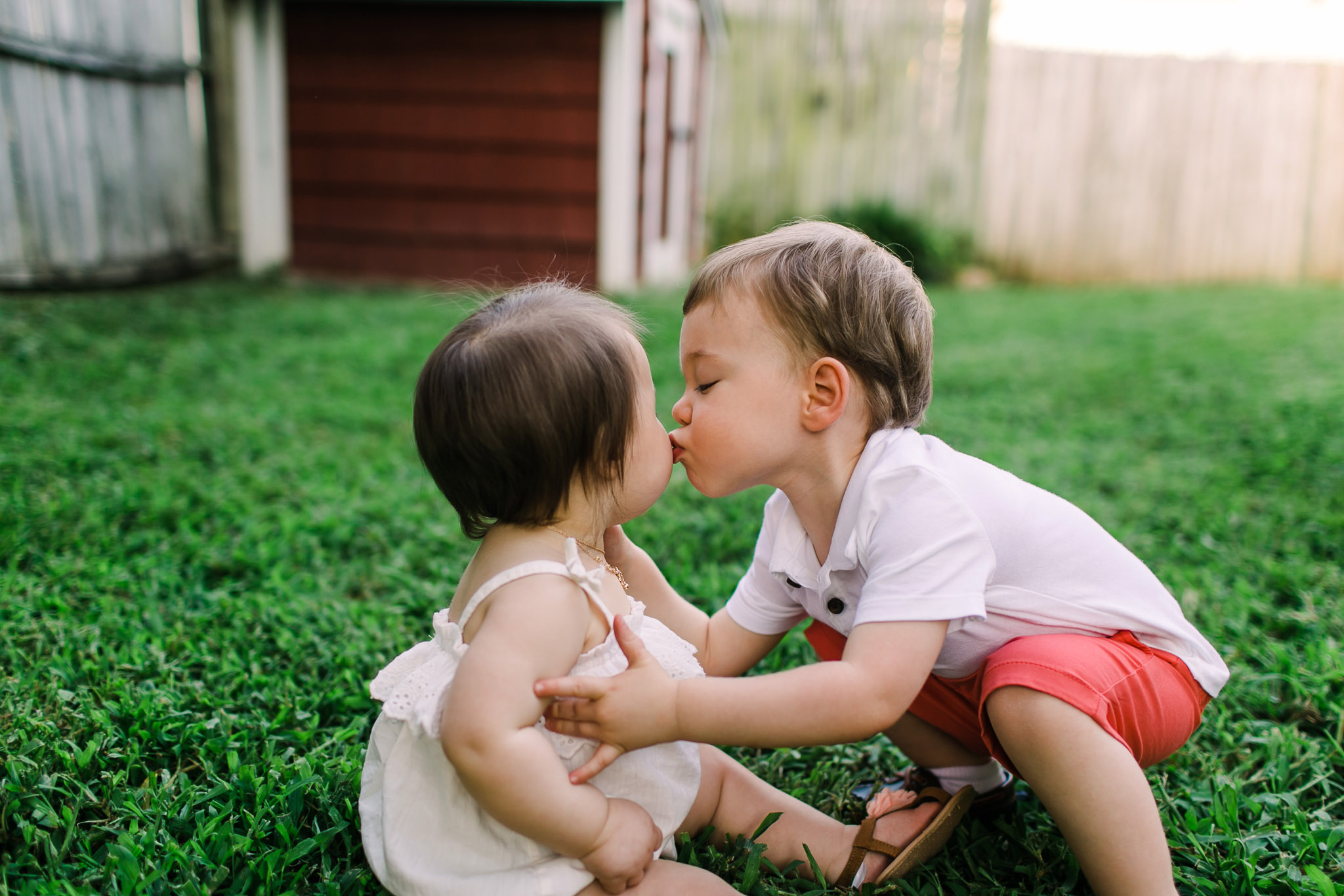 Brother kissing little sister on cheek | Raleigh Children Photography | By G. Lin Photography