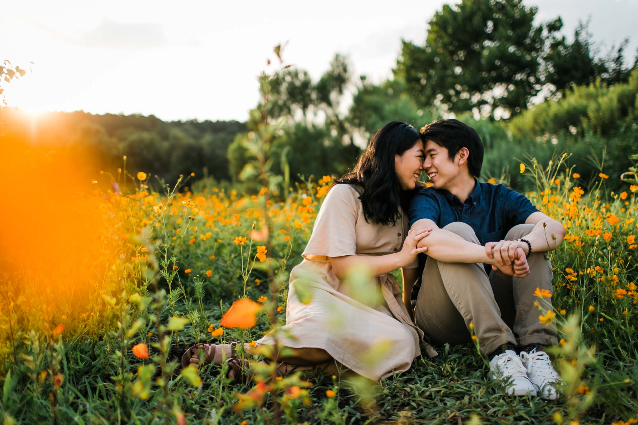 Raleigh Engagement Photographer | By G. Lin Photography | Couple sitting in field of flowers at Dorothea Dix Park