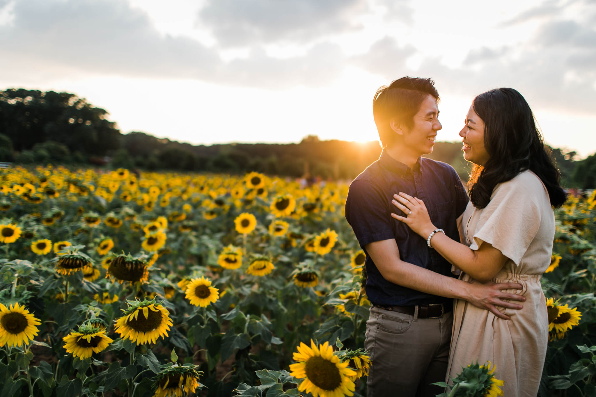 Couple standing in sunflower field at Dorothea Dix Park | By G. Lin Photography | Raleigh Engagement Photographer