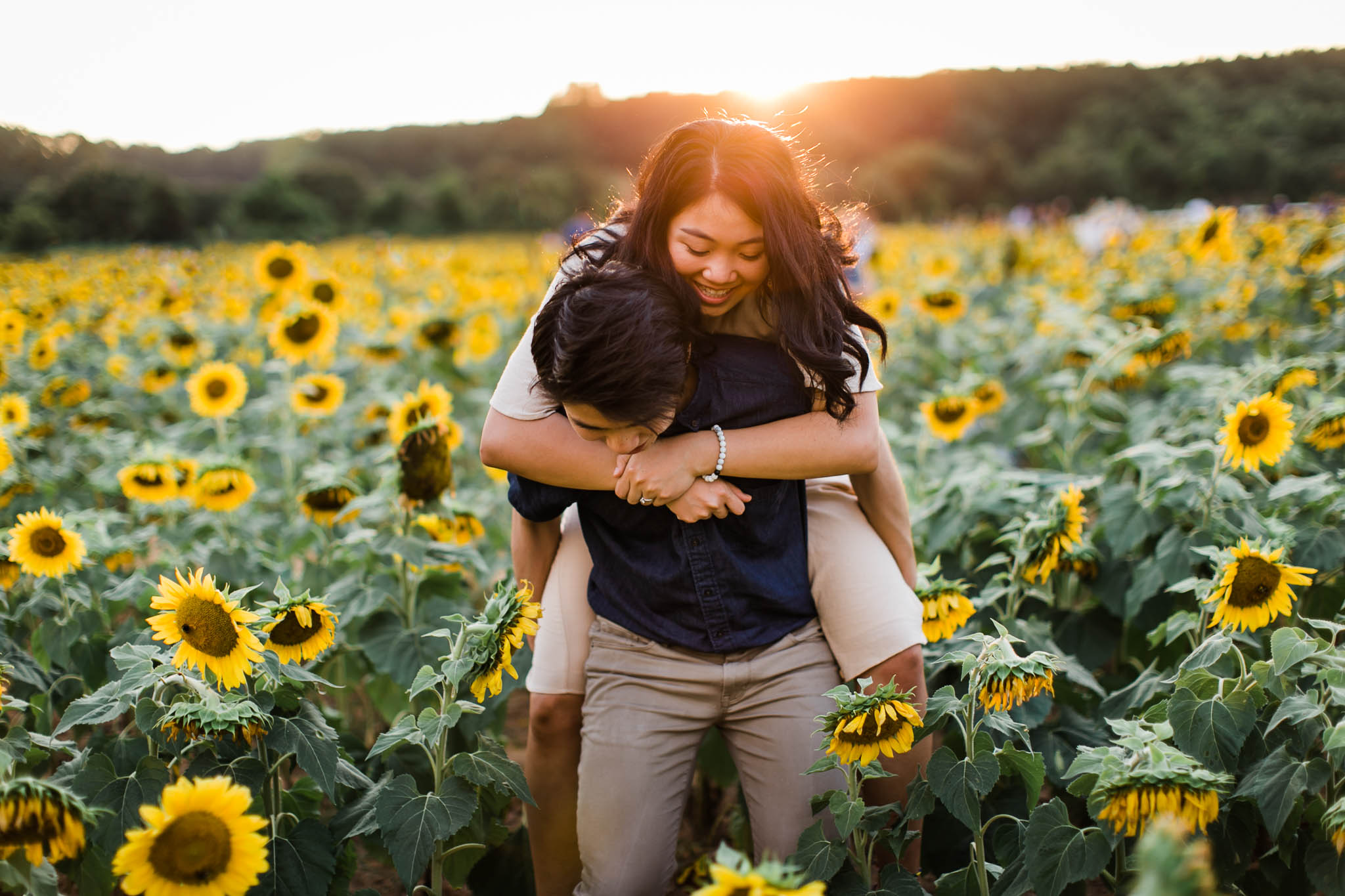 Couple walking through sunflower field at Dorothea Dix Park | By G. Lin Photography | Raleigh Engagement Photographer