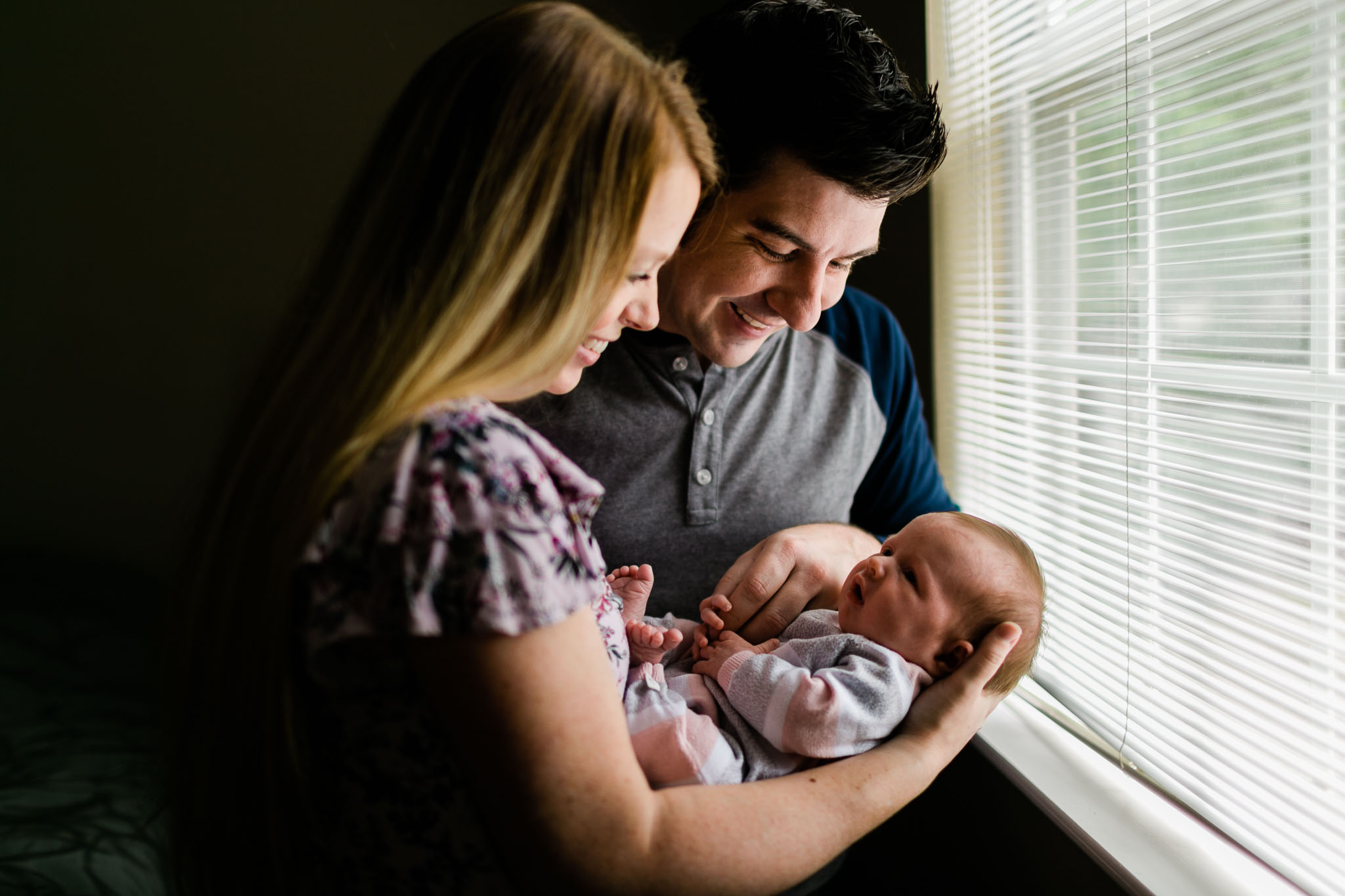 Durham Newborn Photographer | By G. Lin Photography | Mother and father holding baby by window