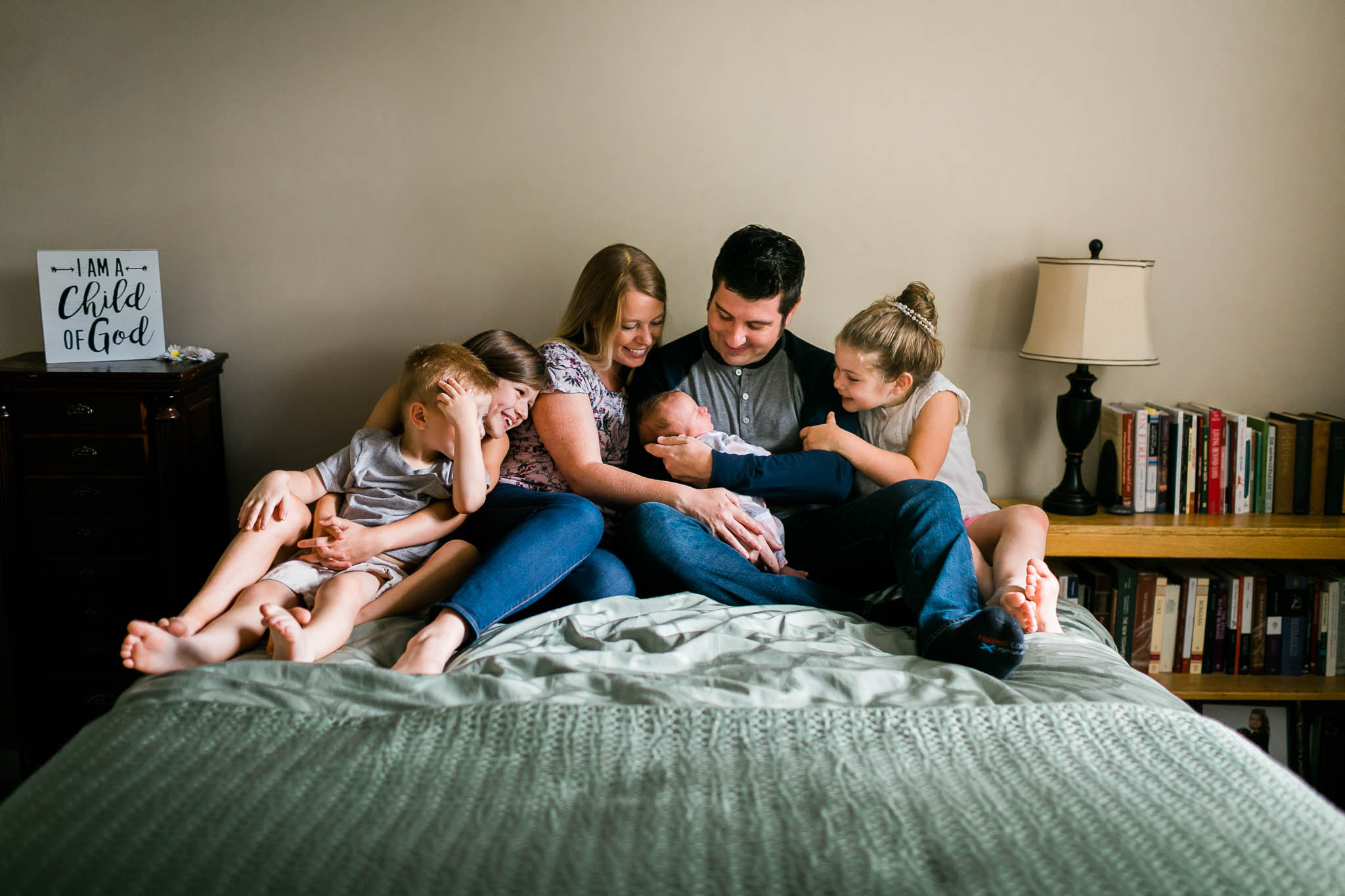 Durham Newborn Photographer | By G. Lin Photography | Family sitting on bed and looking at baby