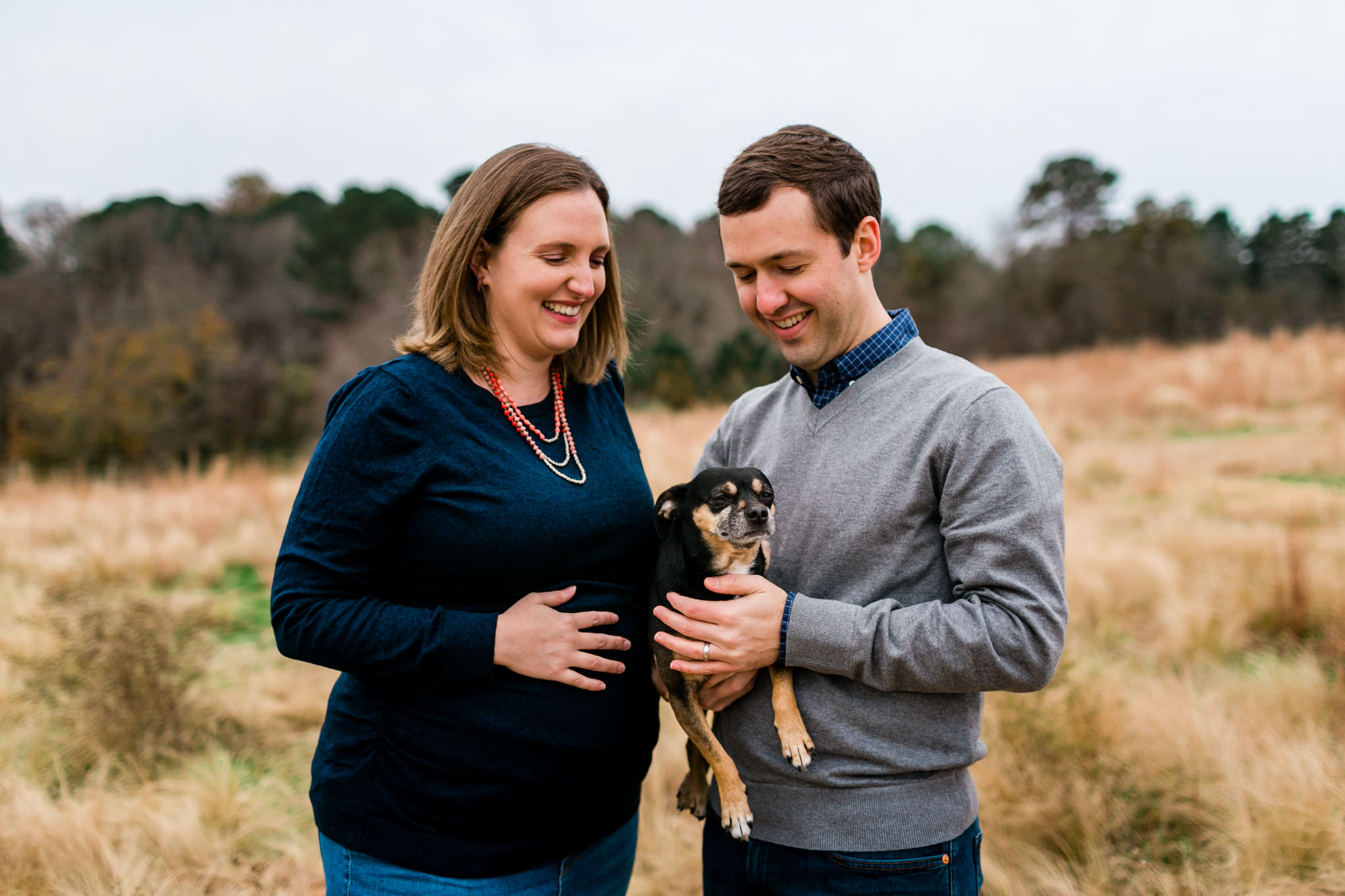 Candid maternity portrait of family with dog in open field | Raleigh Maternity Photographer | By G. Lin Photography