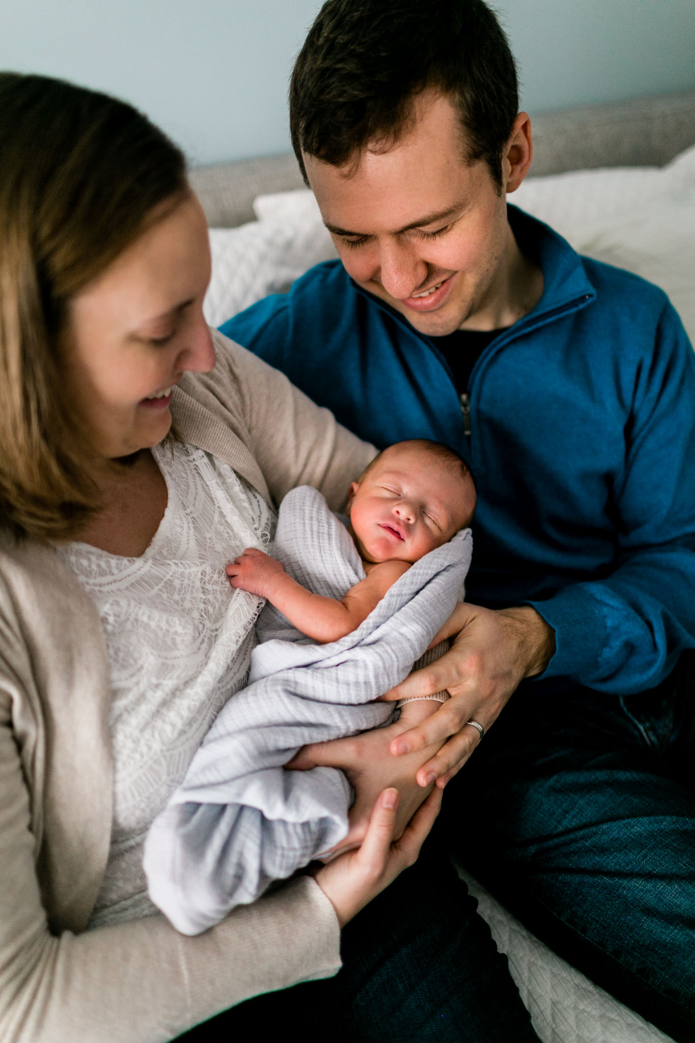 Mother holding baby on bed | Lifestyle Newborn Photographer in Durham NC | By G. Lin Photography