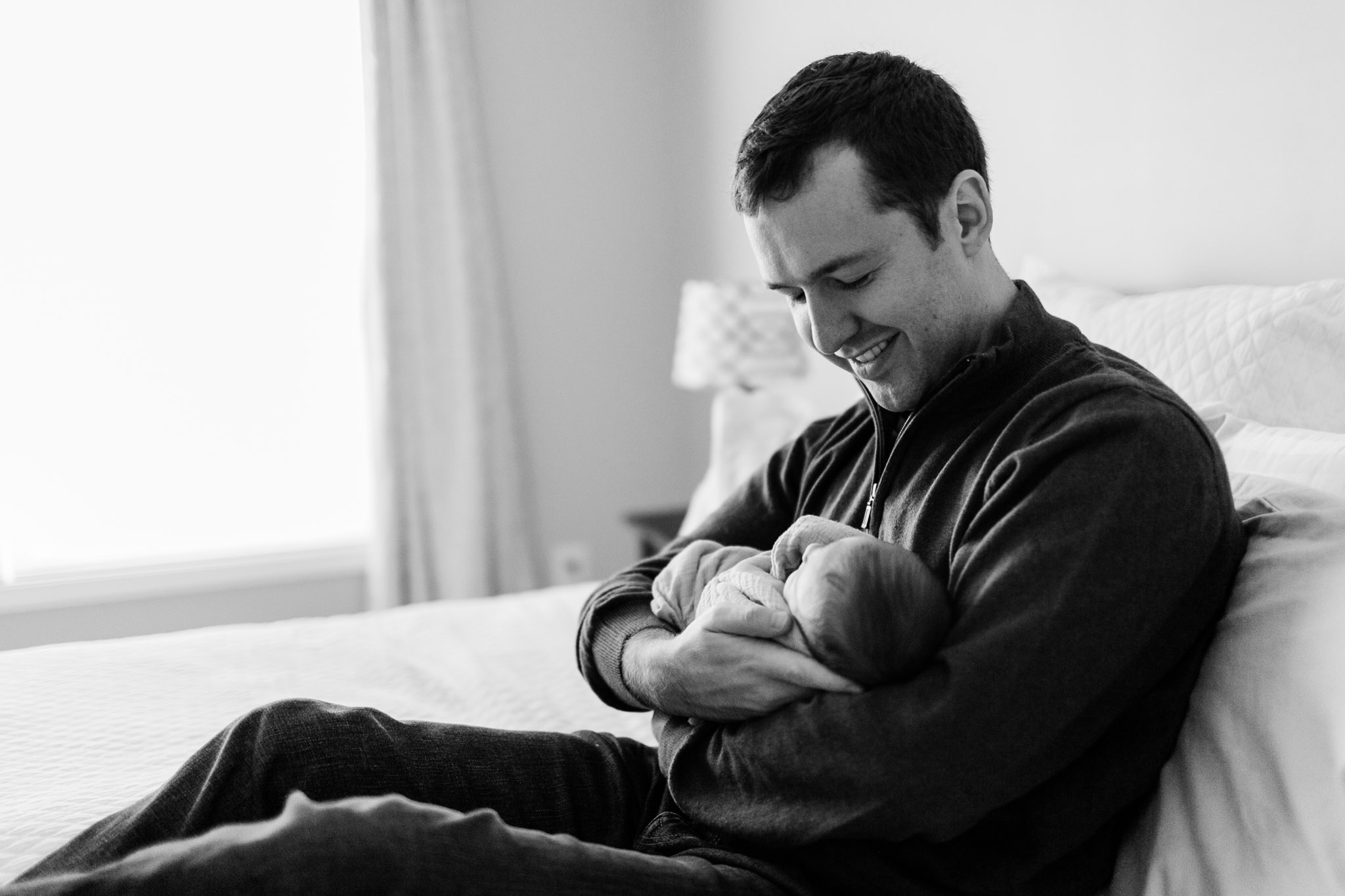 Black and white photo of father holding baby in arms | Raleigh Newborn Photographer | By G. Lin Photography