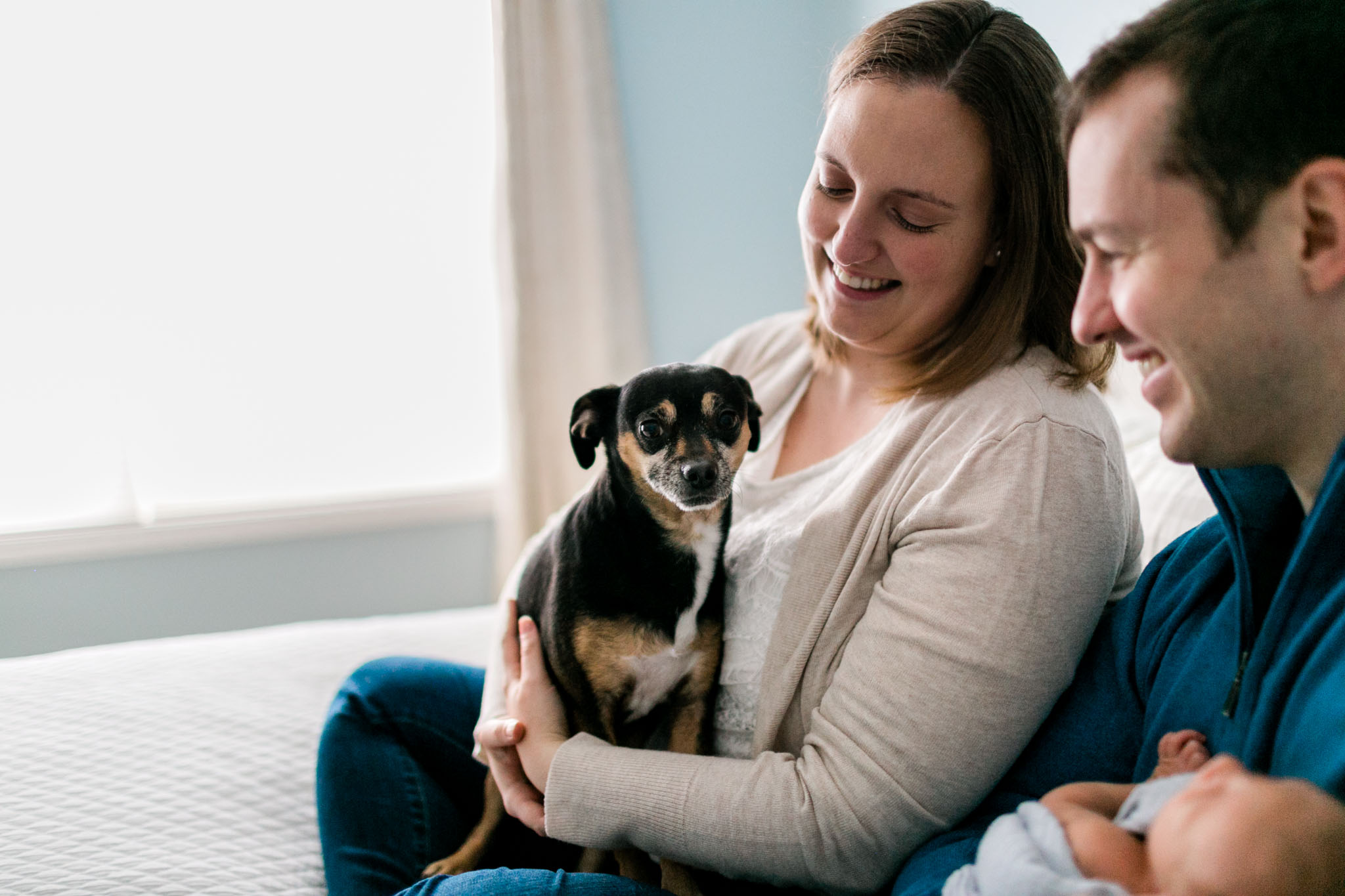 Photo of dog with family sitting on bed | Raleigh Family Photographer | By G. Lin Photography