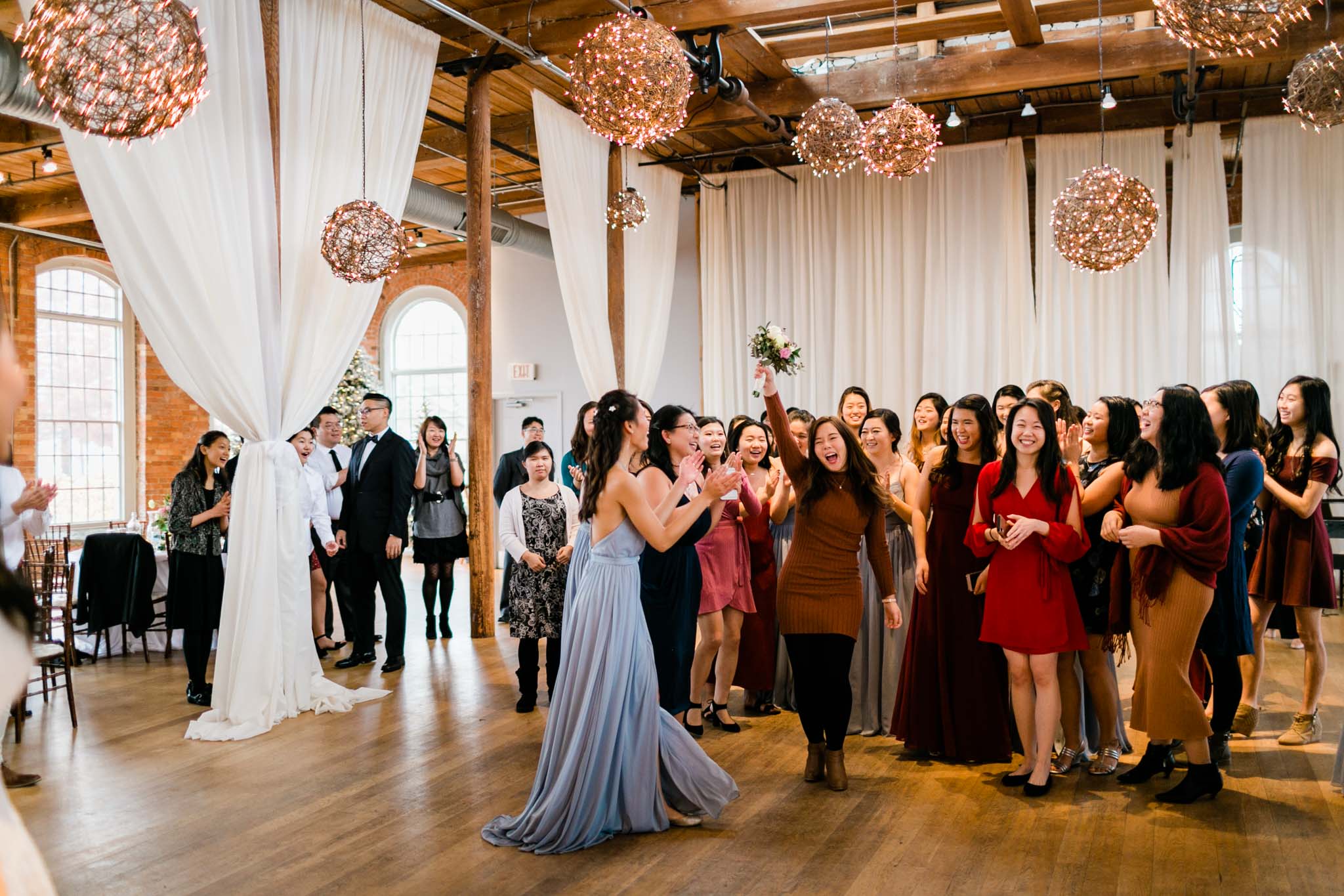 Woman holding bouquet from bouquet toss at The Cotton Room | Durham Event Photographer | By G. Lin Photography