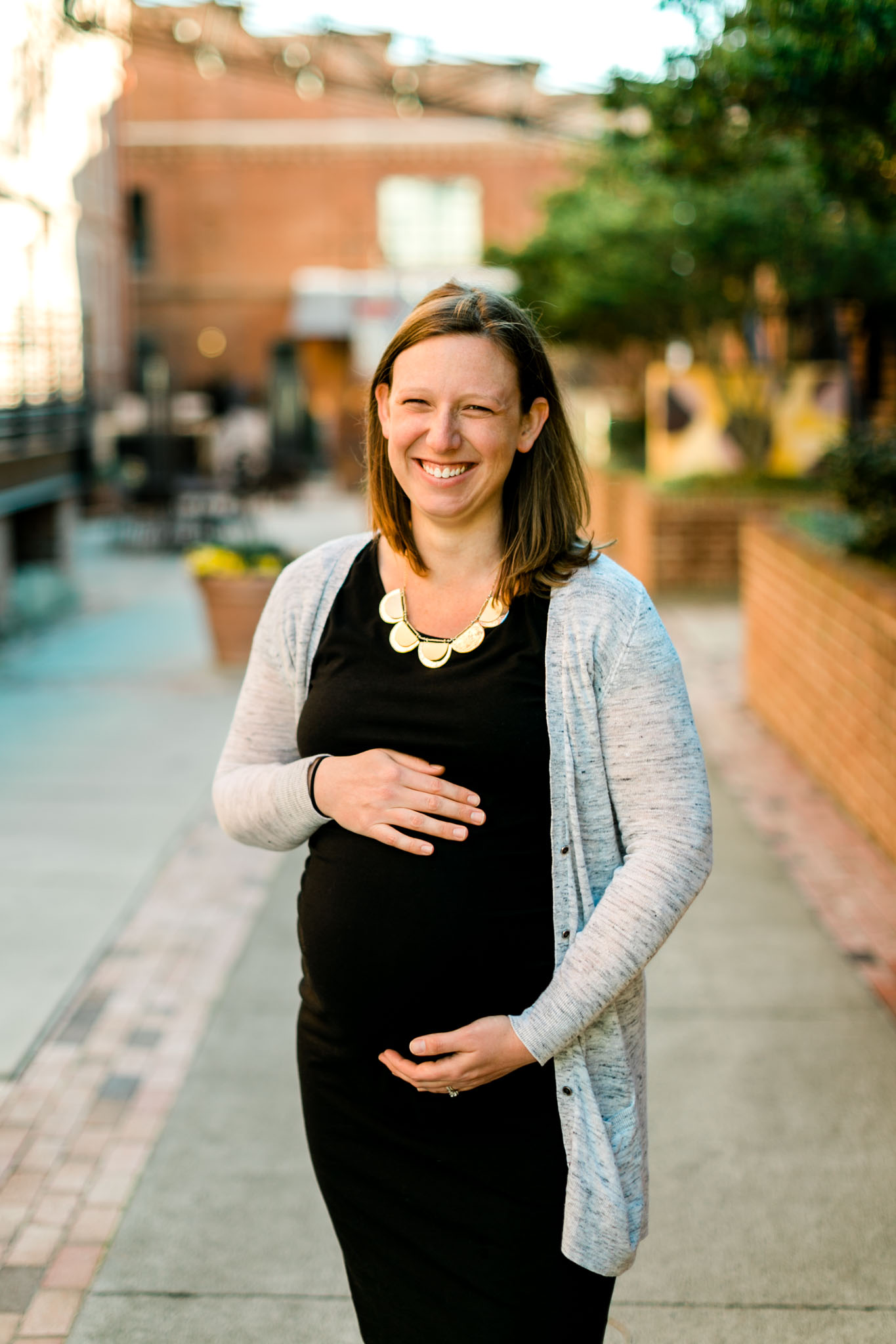 Durham Maternity Photography at American Tobacco Campus | By G. Lin Photography | Candid photo of woman holding baby belly