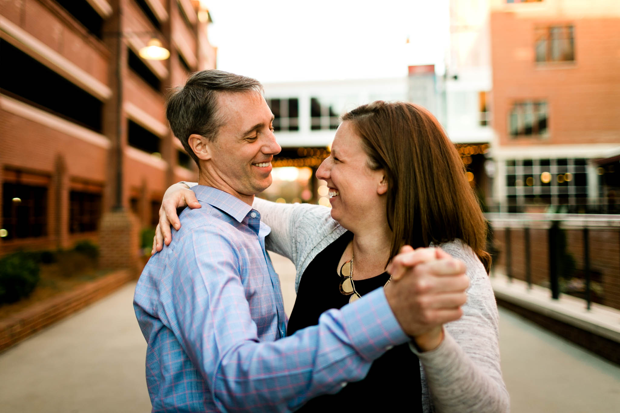Durham Photographer | Couple laughing and dancing at American Tobacco Campus | By G. Lin Photography