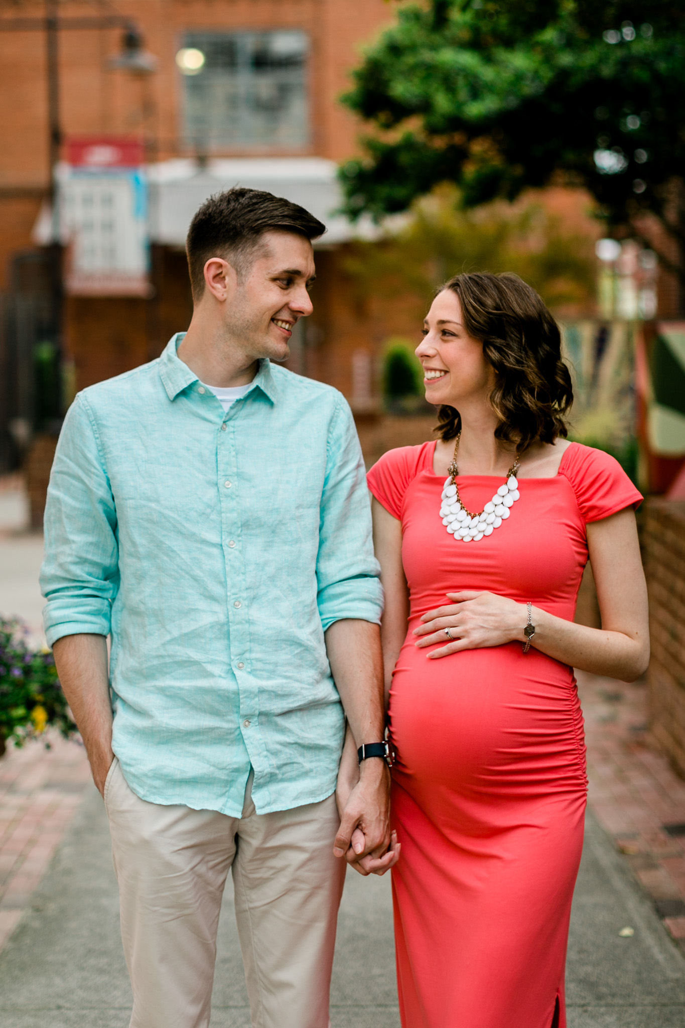 Couple smiling at each other and holding hands | Durham Newborn Photographer | By G. Lin Photography