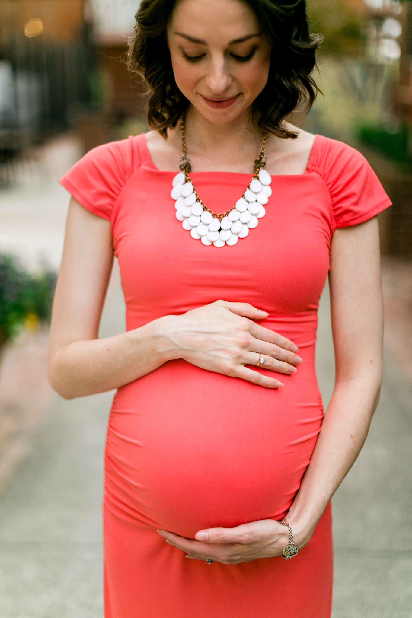 Woman wearing coral dress and holding baby bump | Durham Maternity Photographer | By G. Lin Photography