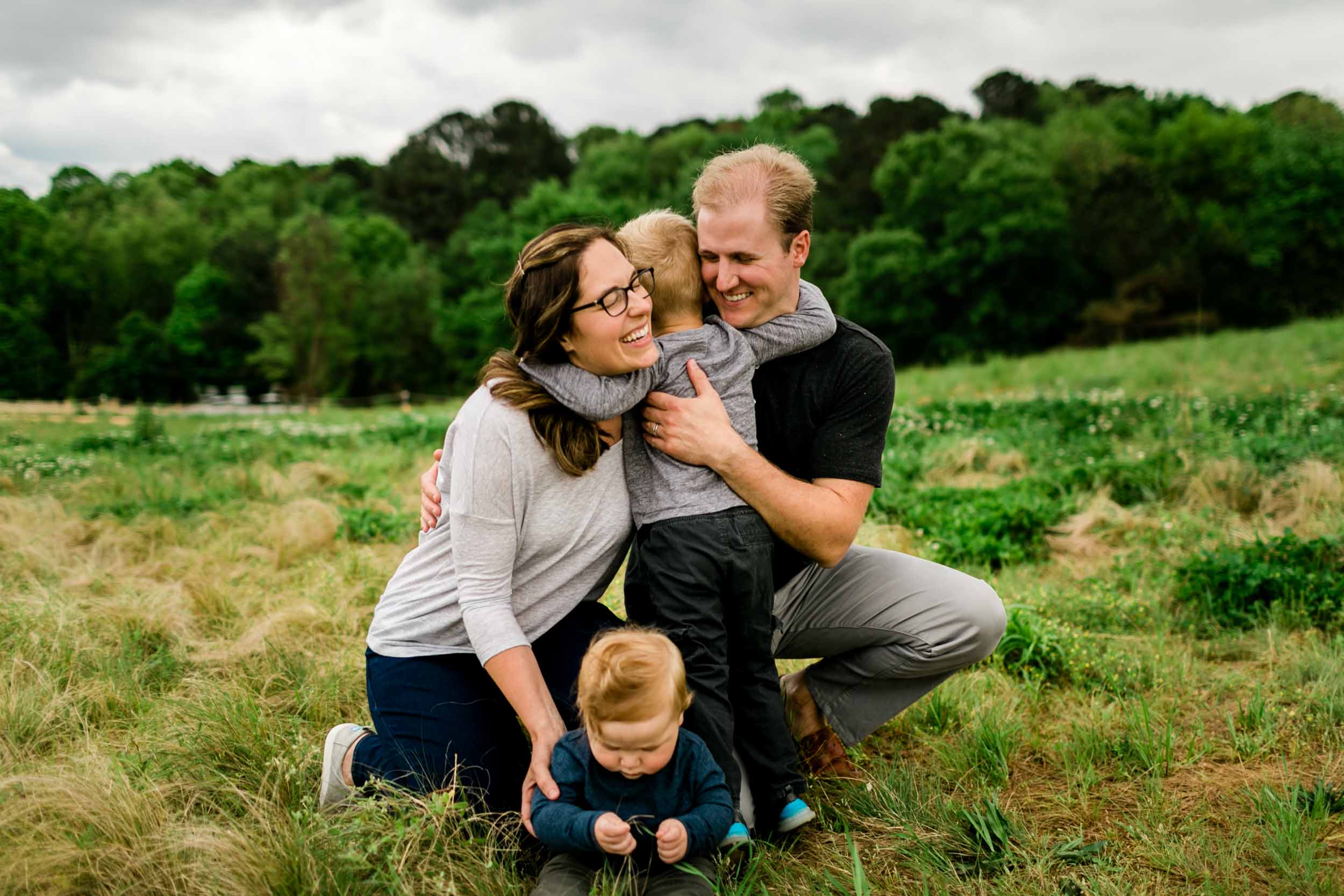 Boy hugging parents in outdoor open field | Raleigh Family Photographer | By G. Lin Photography