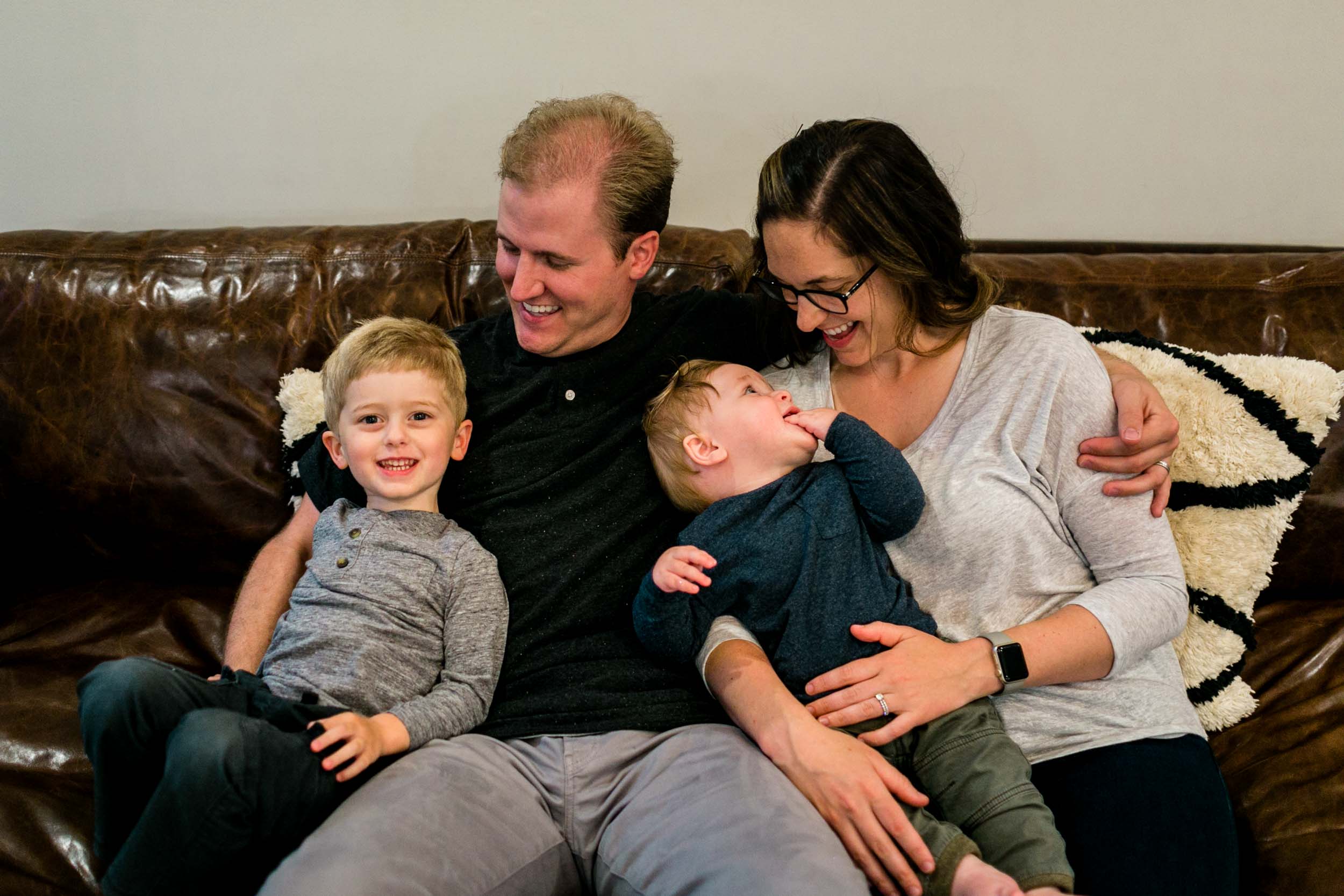 Family laughing together on couch | Raleigh Family Photographer | By G. Lin Photography