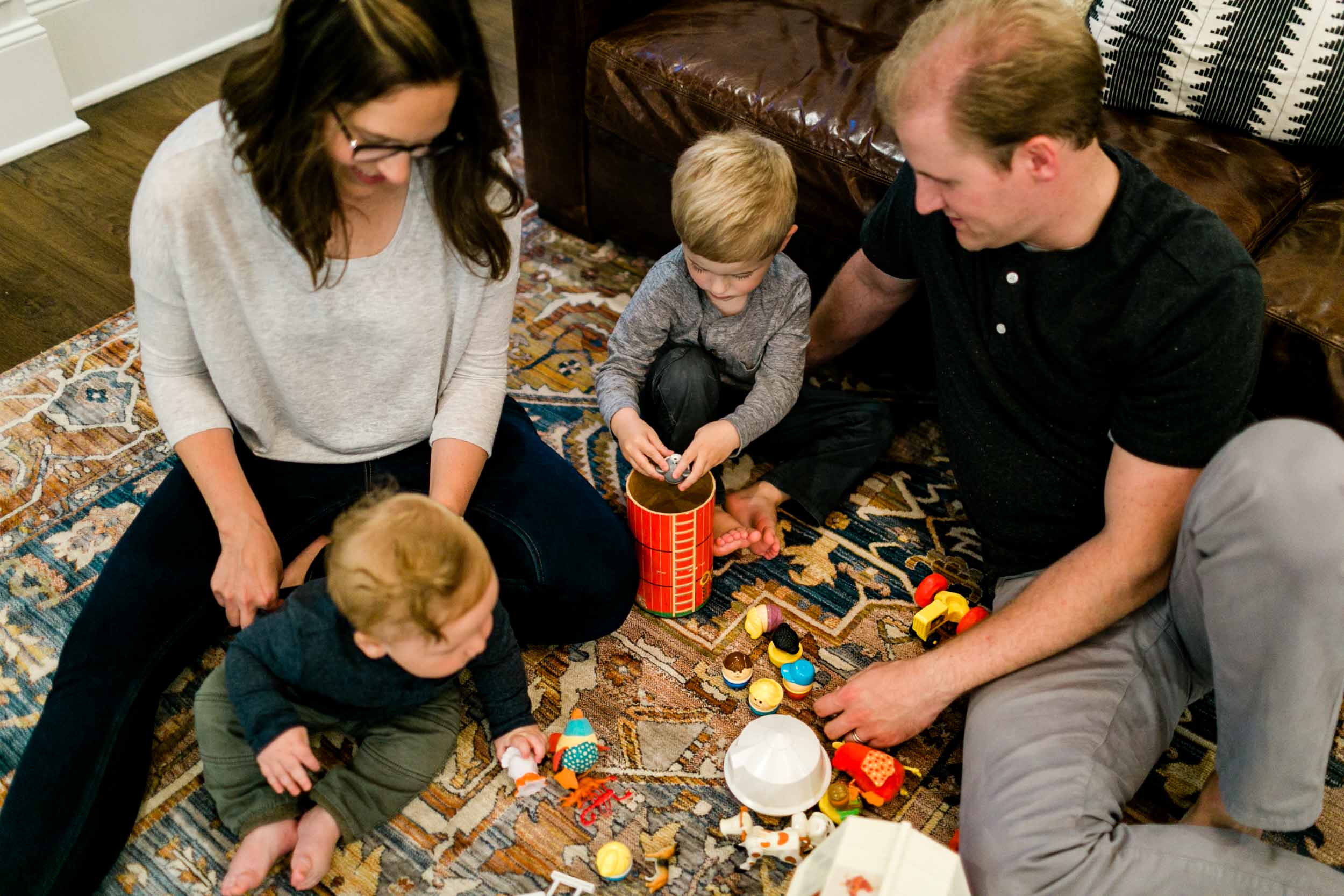 Family sitting on floor playing with toys | Raleigh Family Photographer | By G. Lin Photography