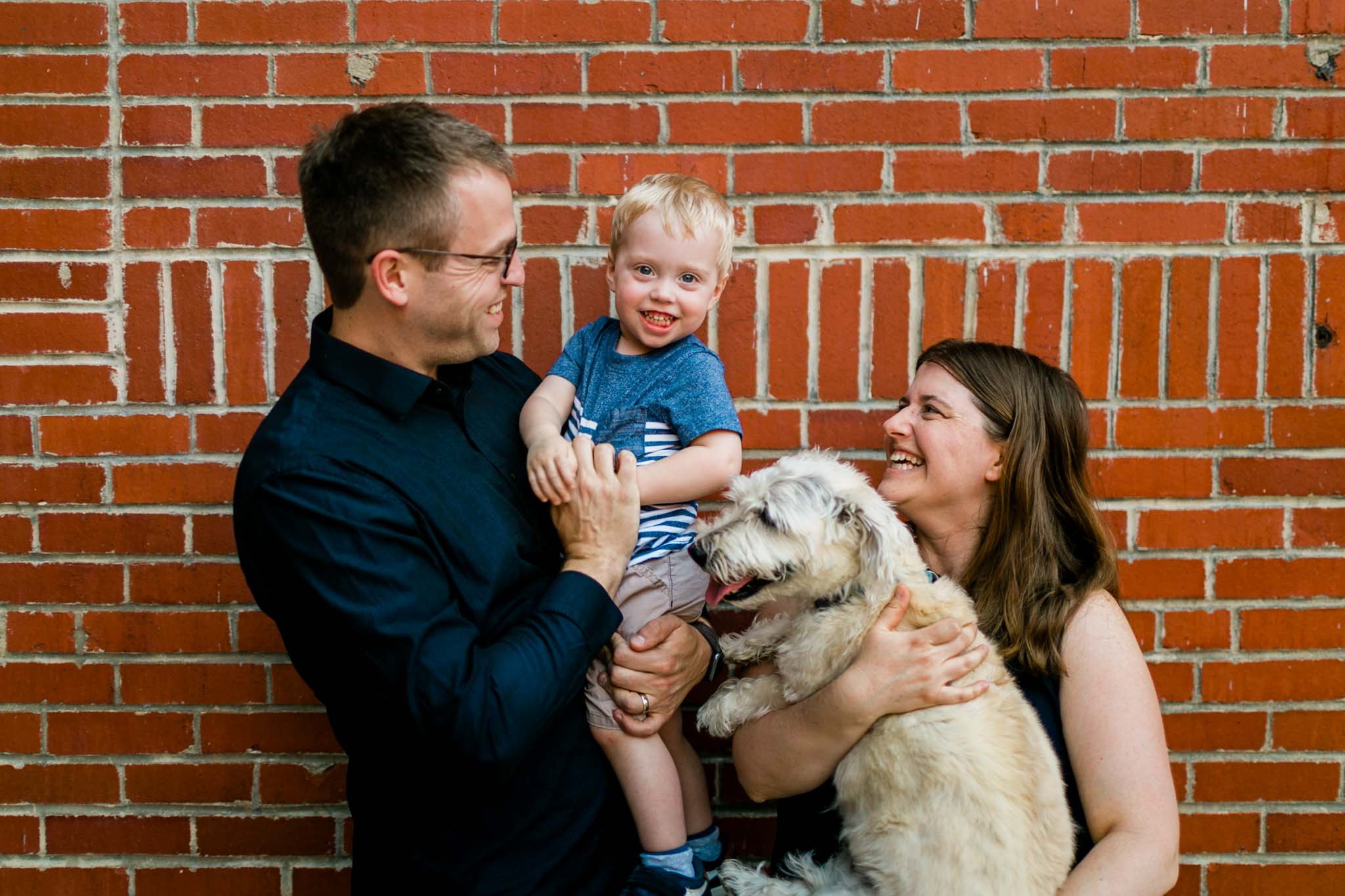 Cute family photo outside against brick wall | Durham Family Photographer | By G. Lin Photography