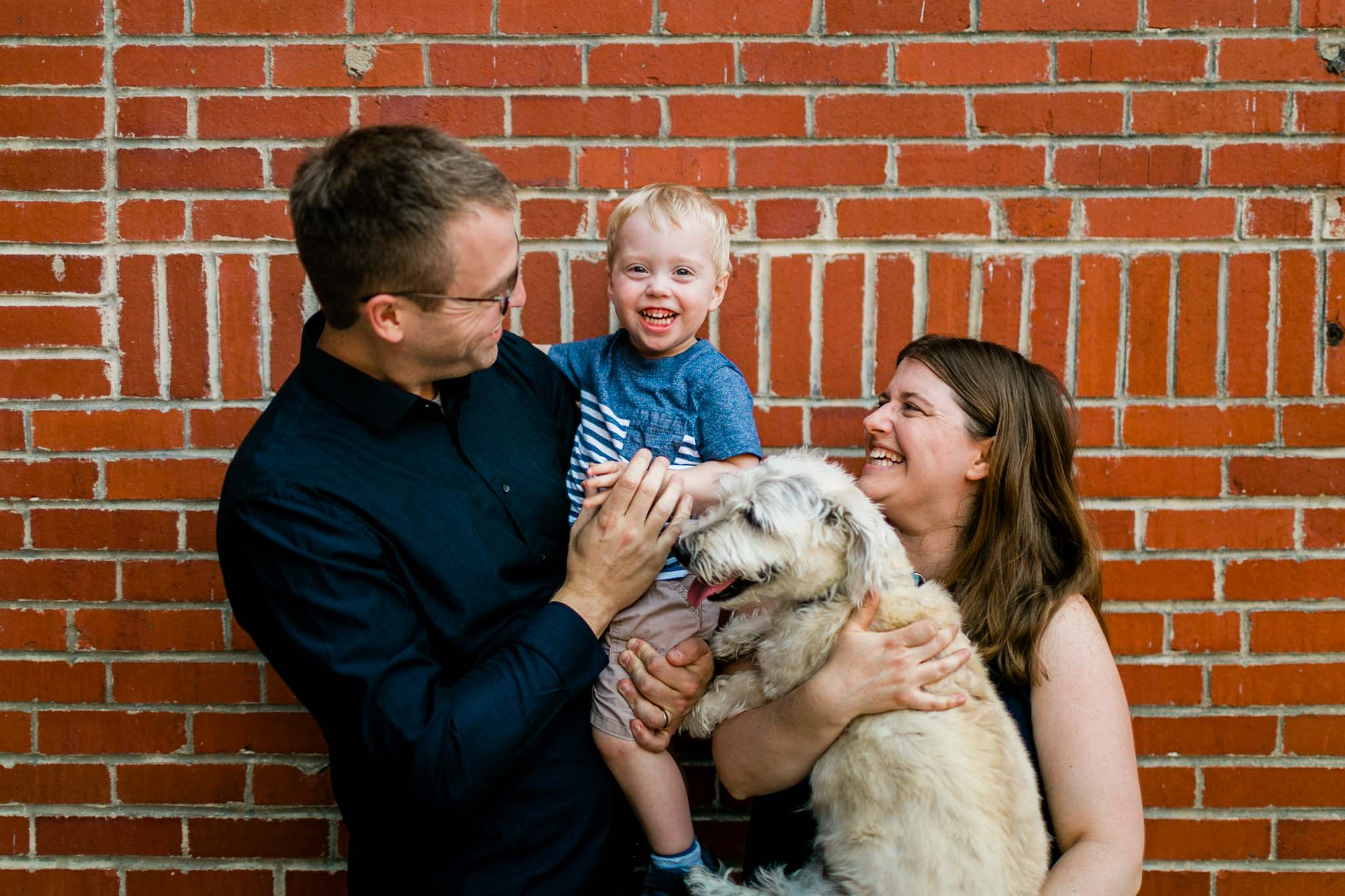 Family laughing together with brick background | Durham Photographer | By G. Lin Photography