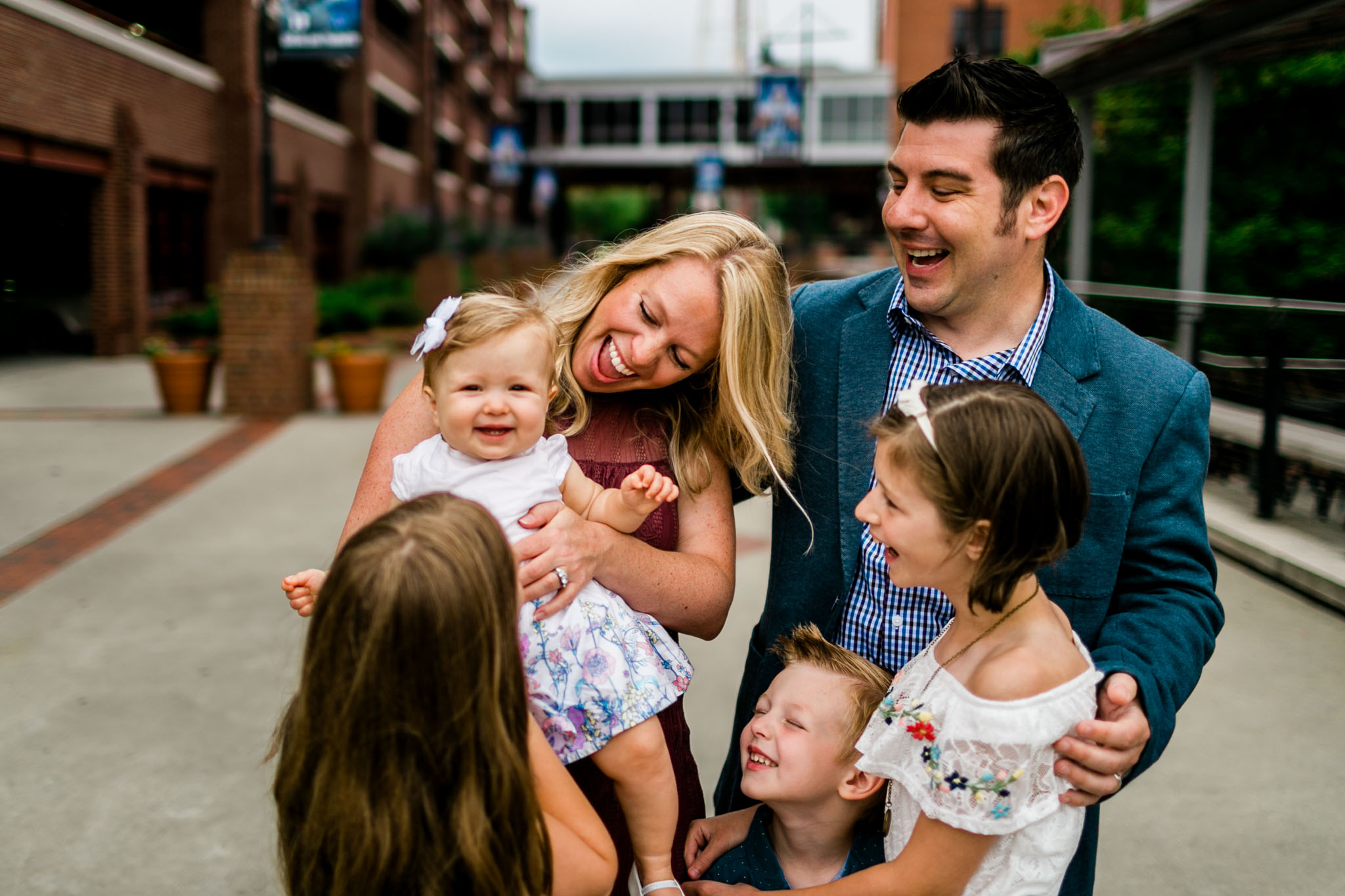 Durham Family Photographer | By G. Lin Photography | Candid portrait of family laughing at American Tobacco Campus