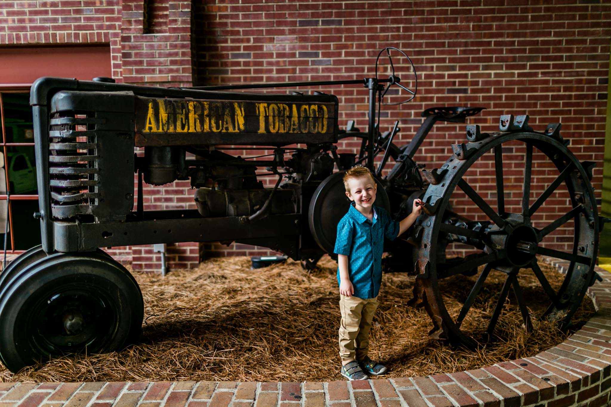 Durham Photographer | By G. Lin Photography | Young buy standing by tractor