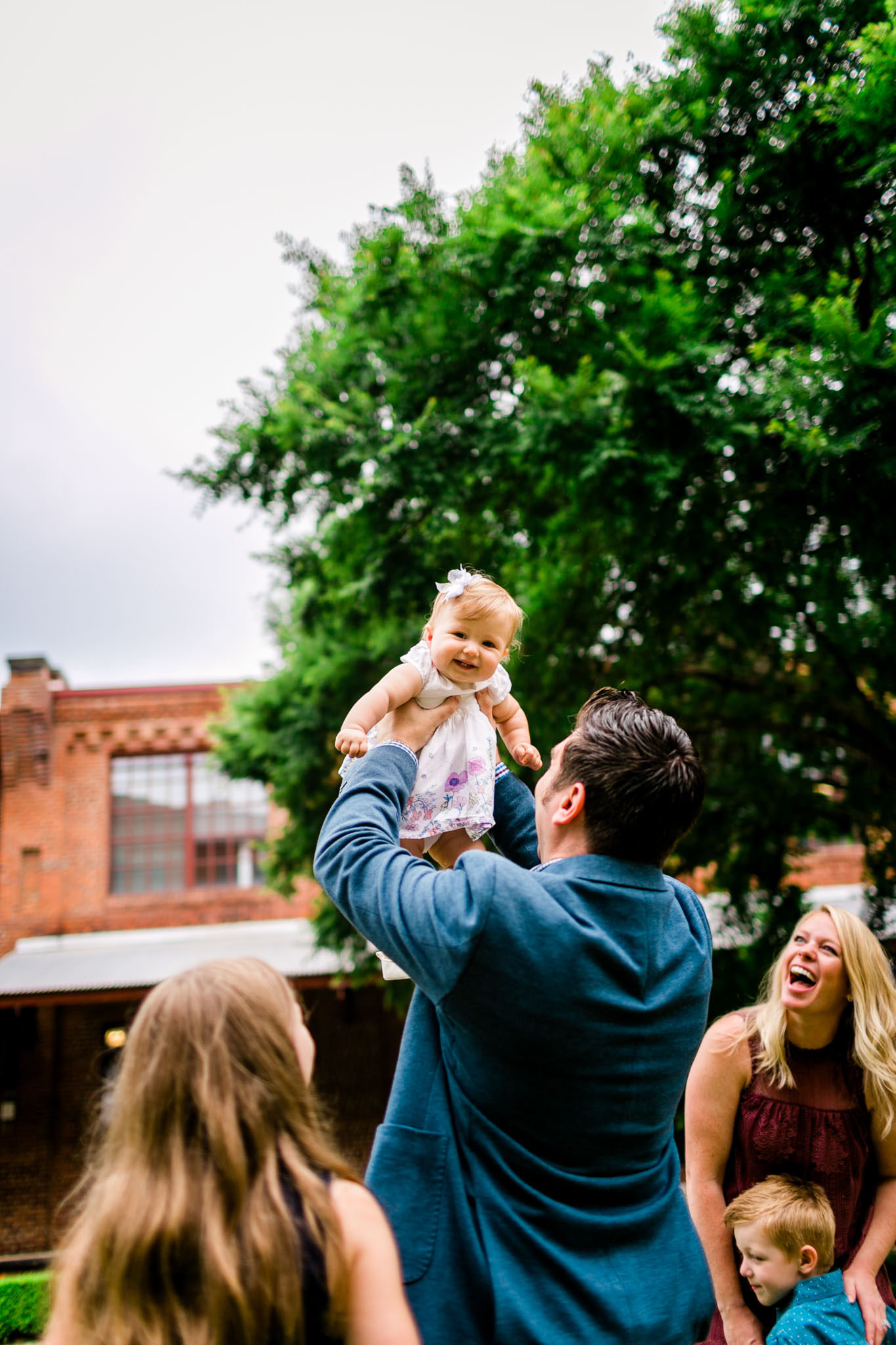 Durham Family Photographer | By G. Lin Photography | Candid lifestyle photo of dad tossing baby girl in the air