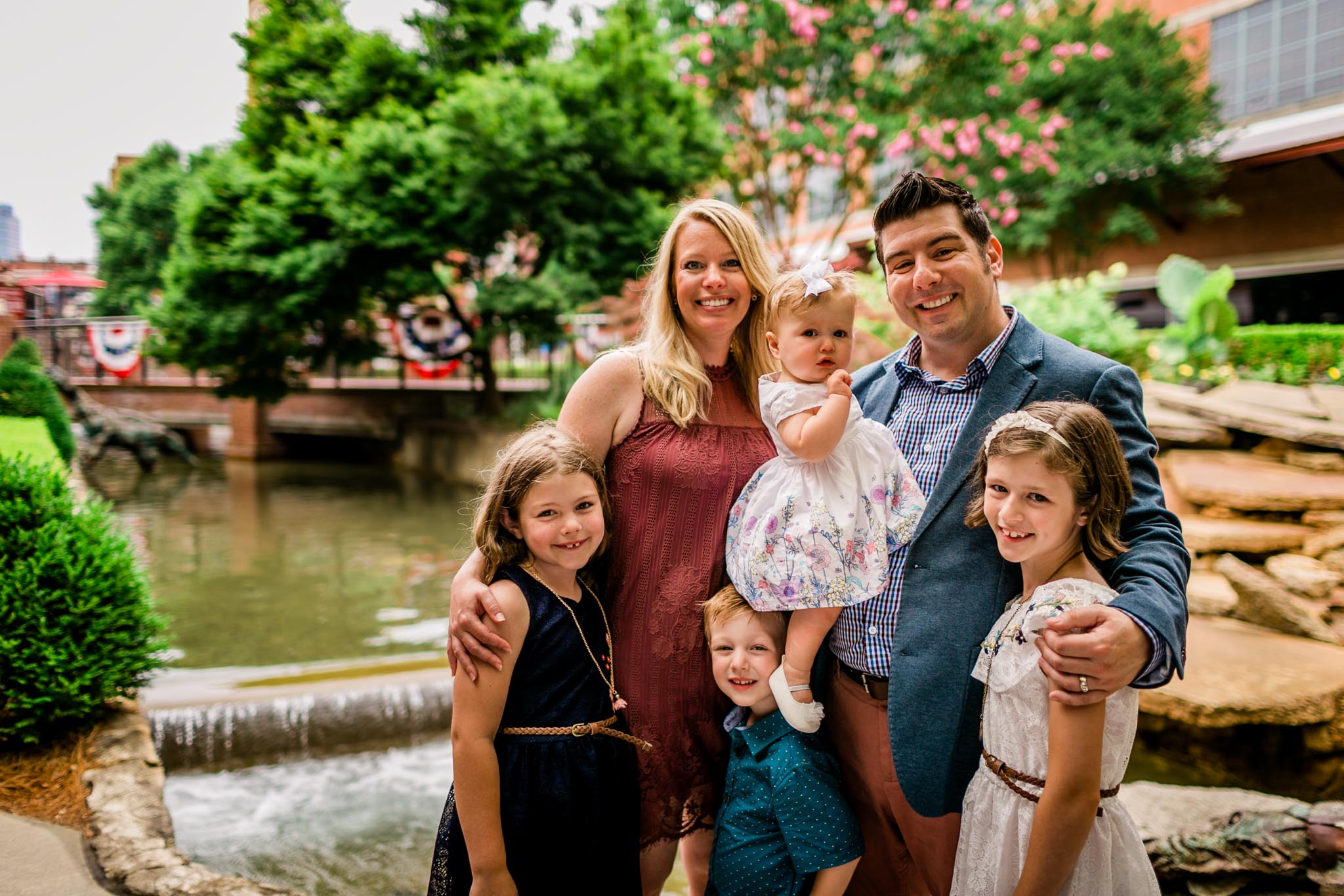 Durham Family Photographer | By G. Lin Photography | Portrait of family outdoors at American Tobacco Campus by waterfall