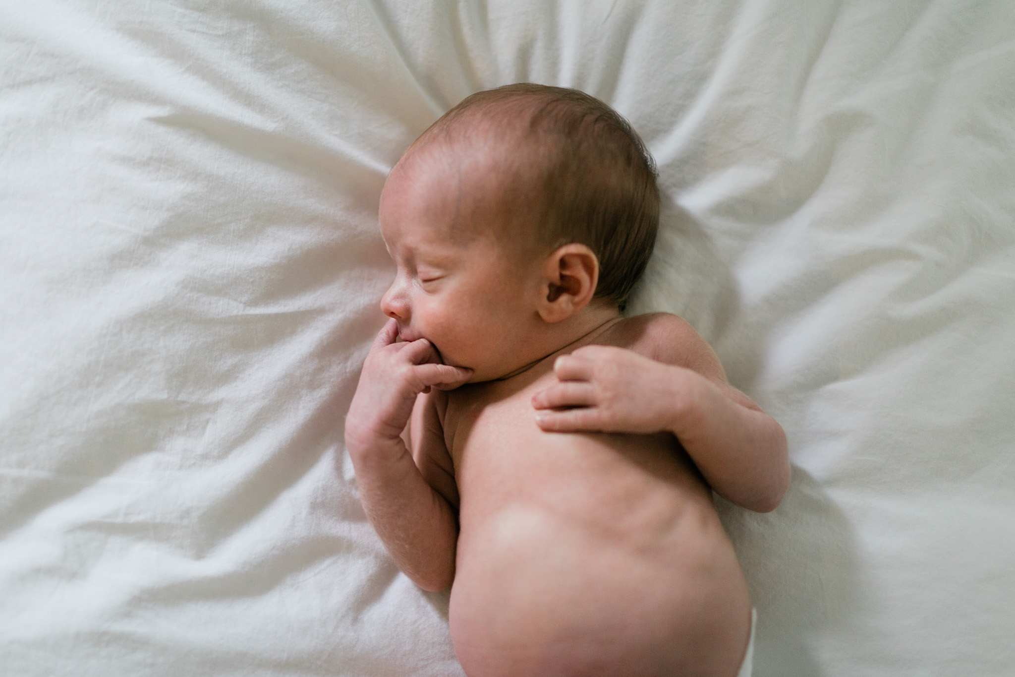 Durham Newborn Photographer | By G. Lin Photography | Baby sleeping on white sheets on bed