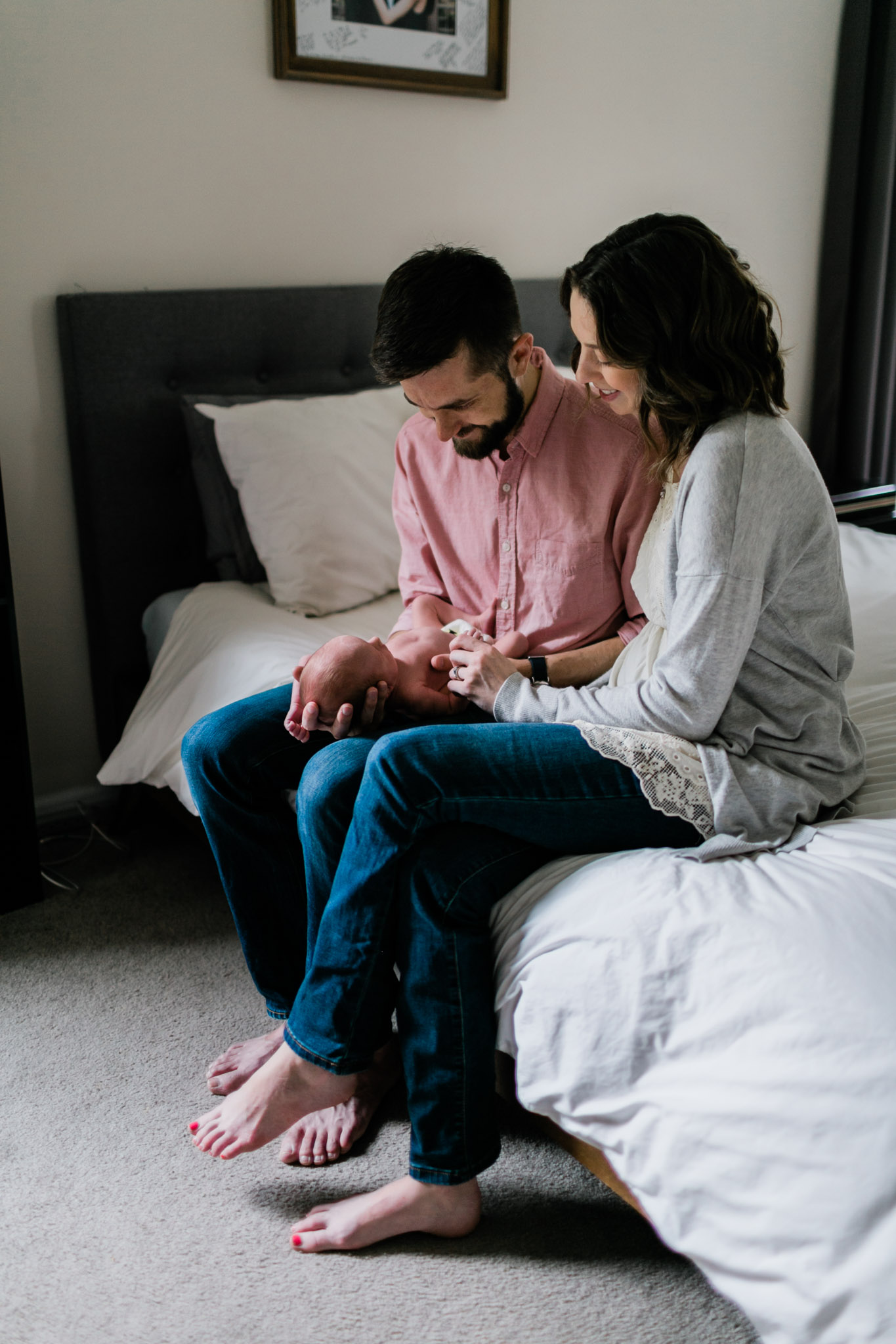 Durham Newborn Photographer | By G. Lin Photography | Parents holding baby on bed