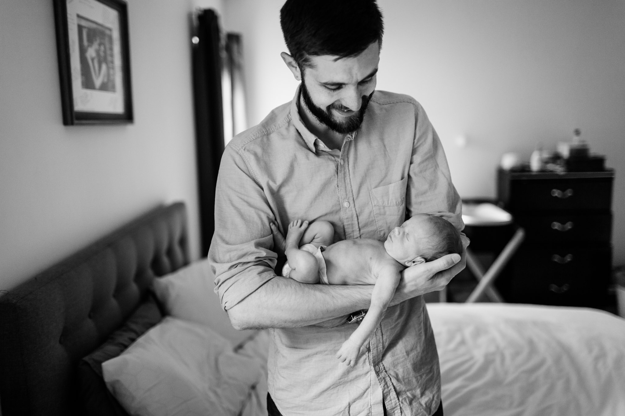 Durham Newborn Photographer | By G. Lin Photography | Dad rocking baby in arms by window