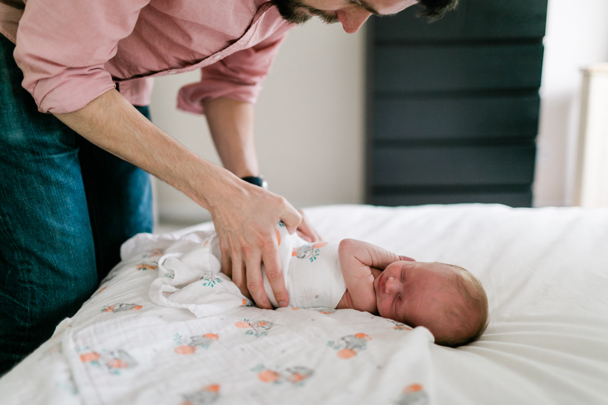 Raleigh Newborn Photographer | By G. Lin Photography | Dad swaddling baby on bed