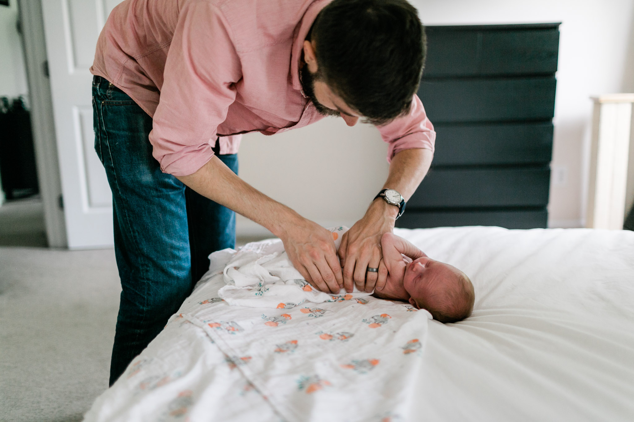 Durham Newborn Photographer | By G. Lin Photography | Dad swaddling baby on bed