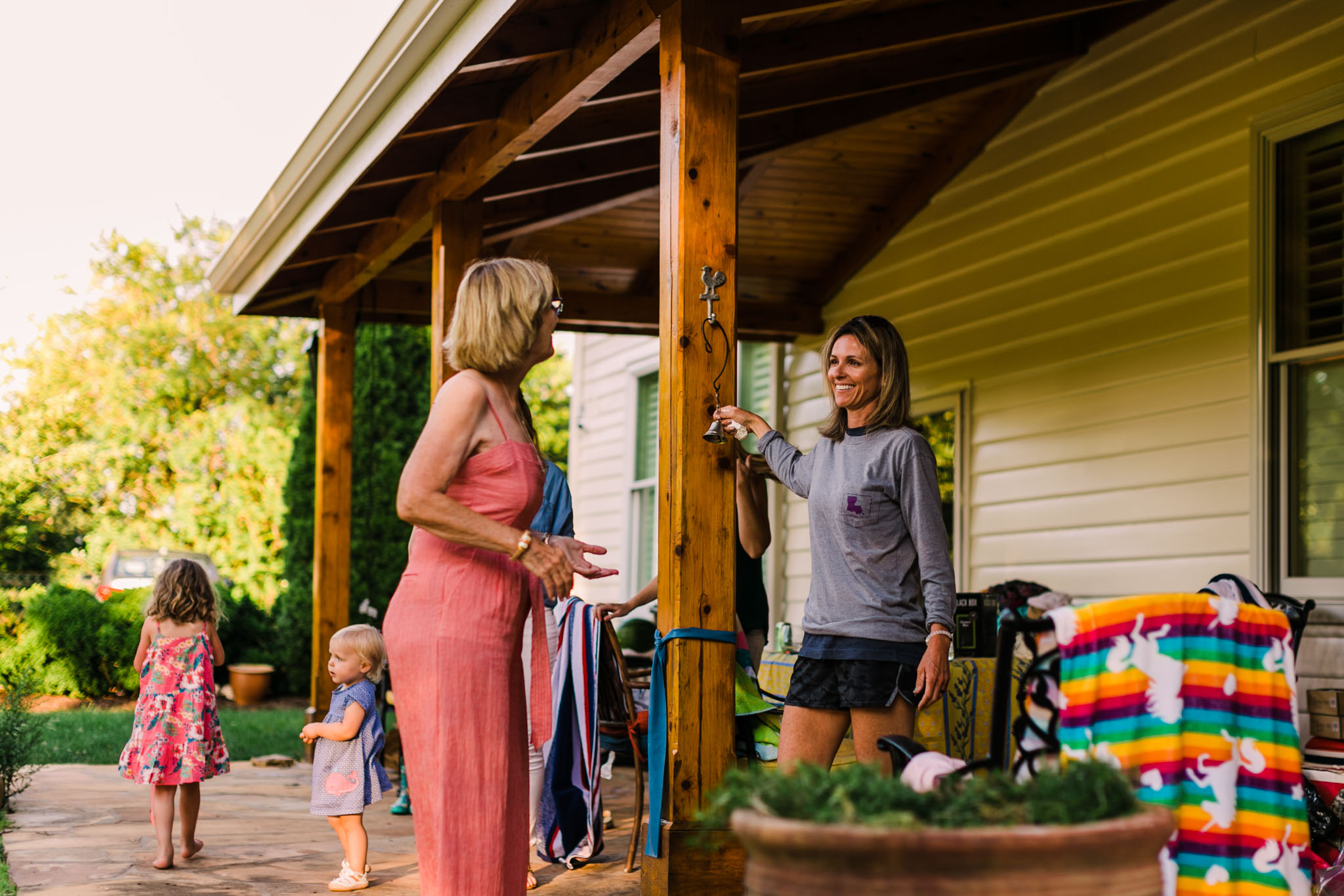 Durham Family Photographer | By G. Lin Photography | Woman ringing dinner bell outside
