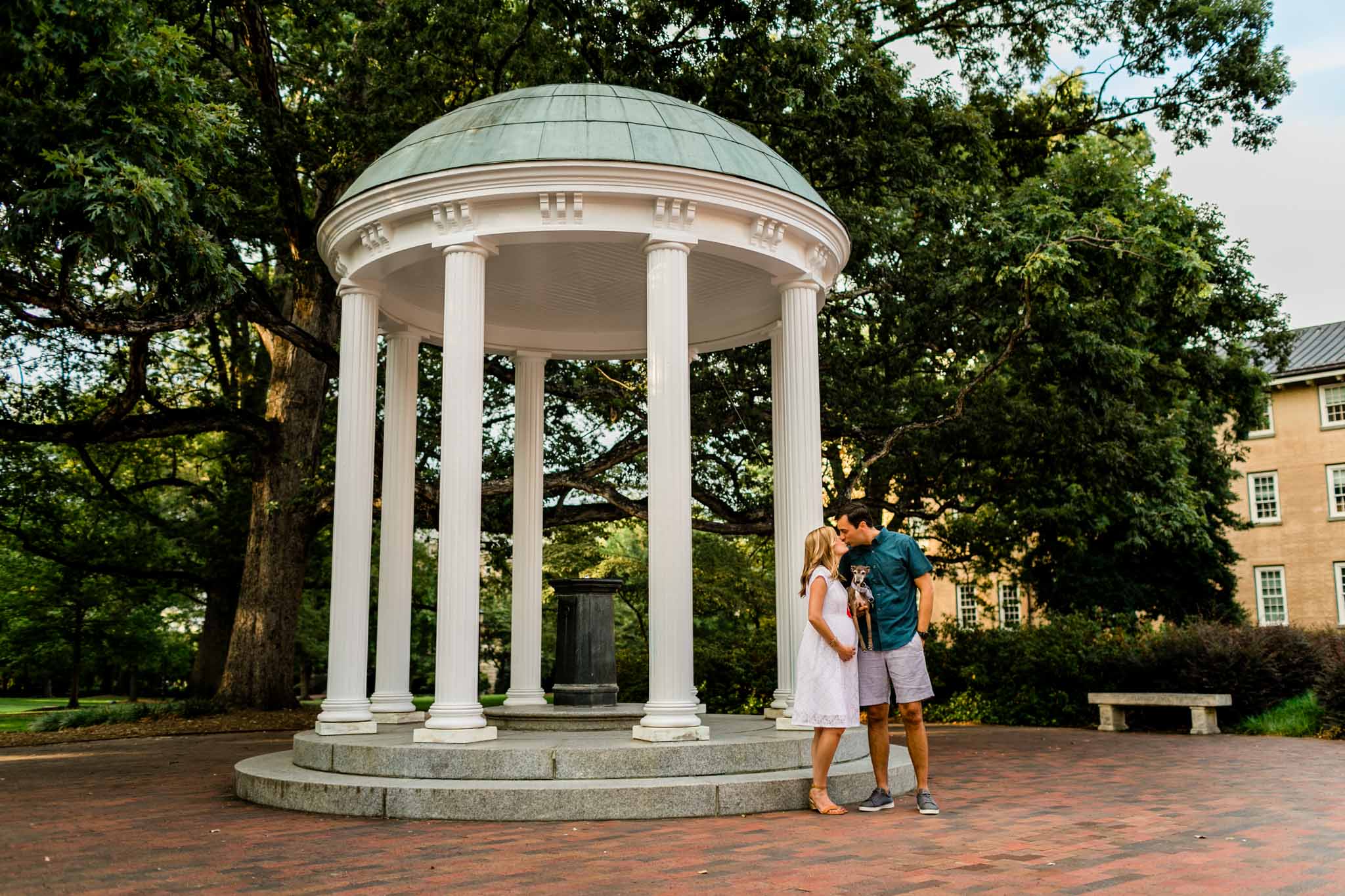 UNC Chapel Hill Maternity Photography | By G. Lin Photography | Couple kissing by the Old Well UNC
