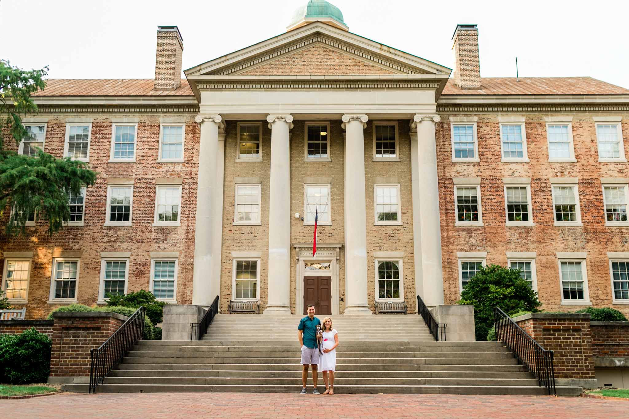Chapel Hill Maternity Photographer at UNC | By G. Lin Photography | Couple standing in front of South Building