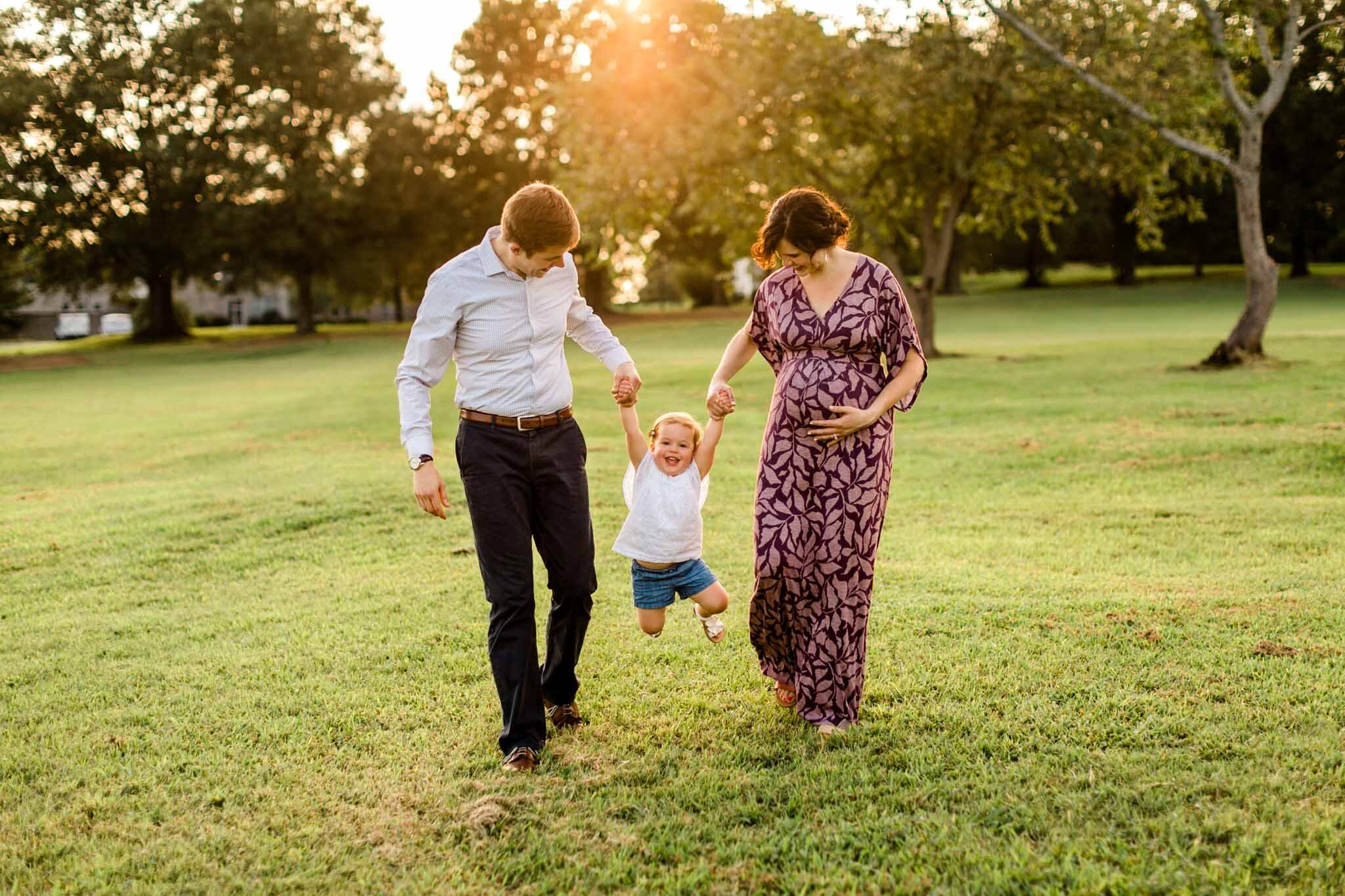 Raleigh Family Photographer at Dix Park | By G. Lin Photography | Parents swinging daughter outside