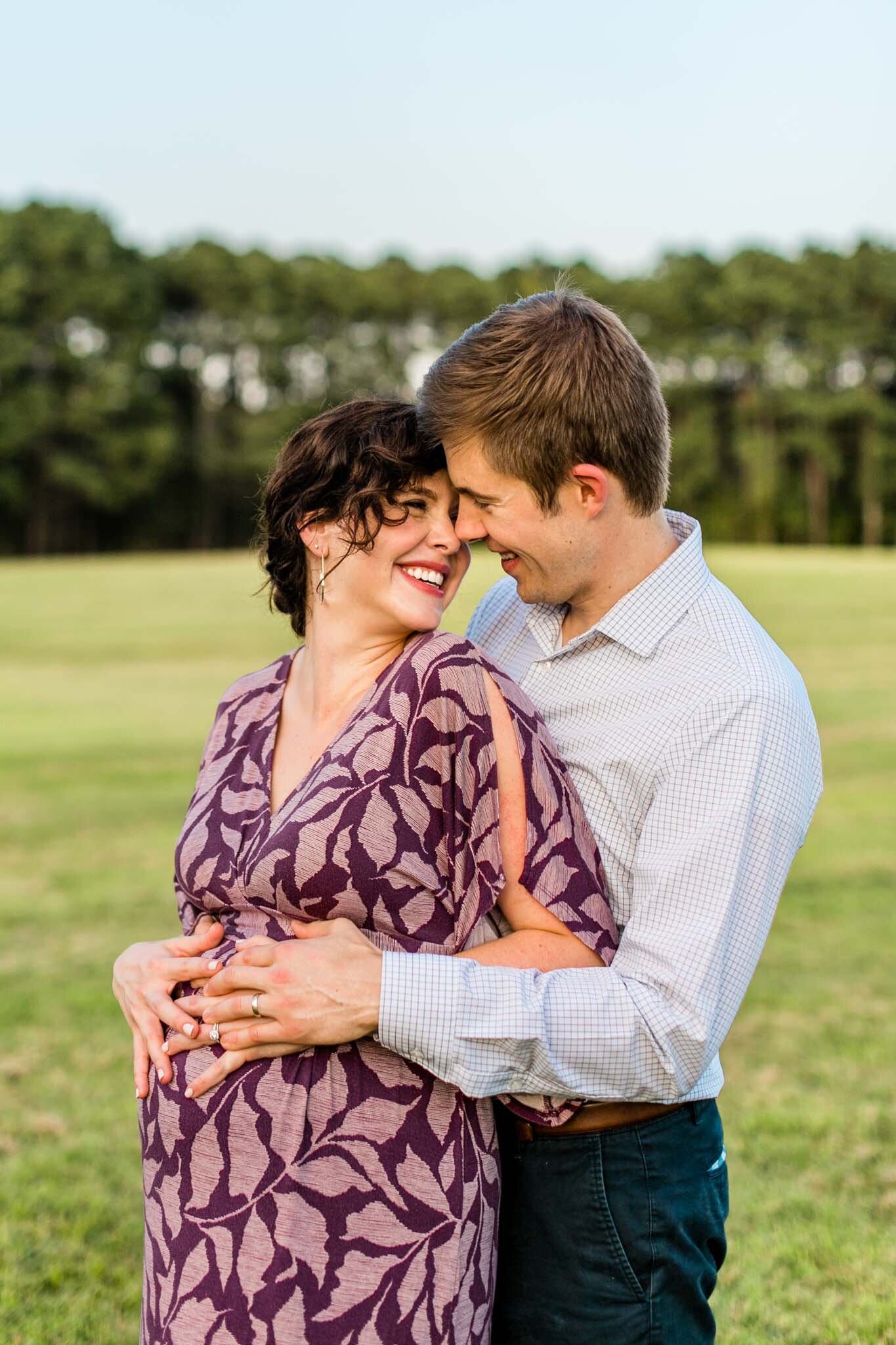 Raleigh Maternity Photography at Dix Park | By G. Lin Photography | Couple smiling together in open field
