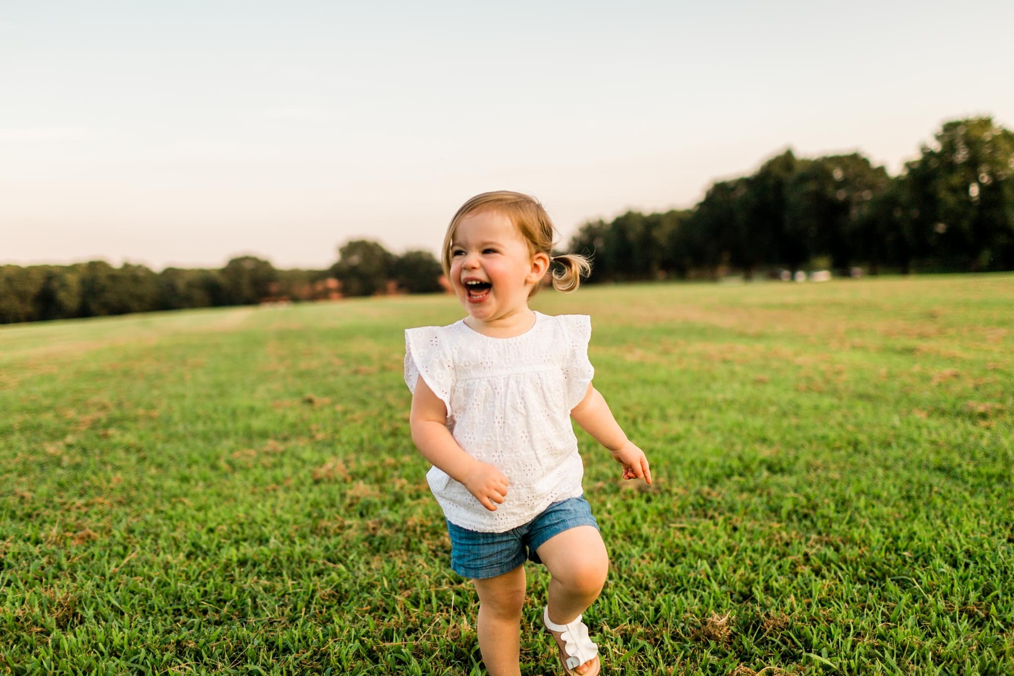 Girl running in open field during sunset at Dix Park | Raleigh Family Photographer | By G. Lin Photography